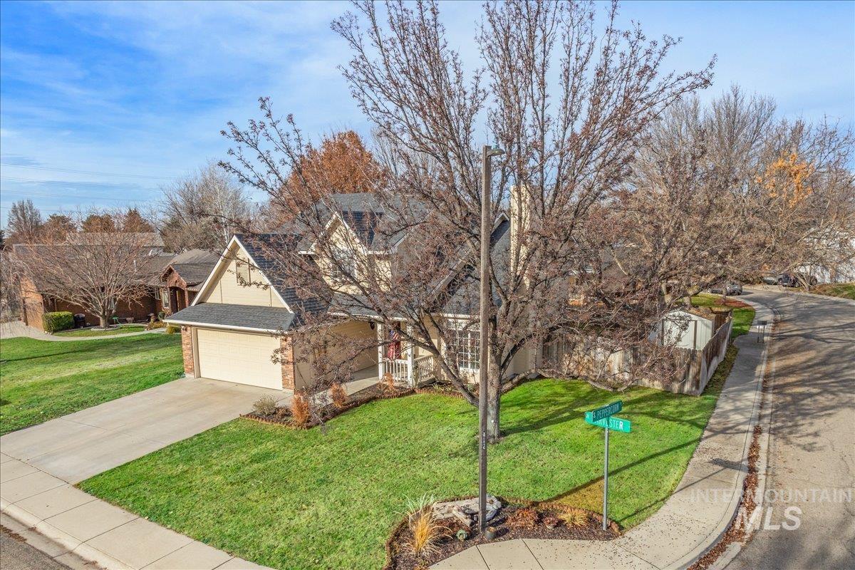 View of front of home with brick siding, a front yard, concrete driveway, and a garage