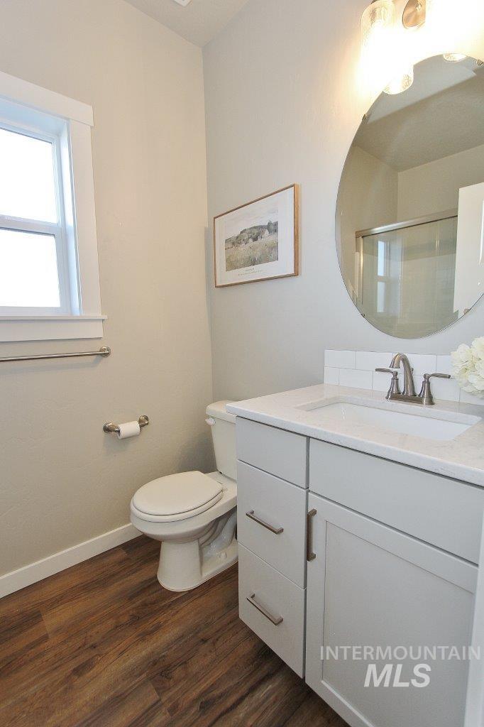 Full bath with vanity, a shower stall, and dark wood finished floors