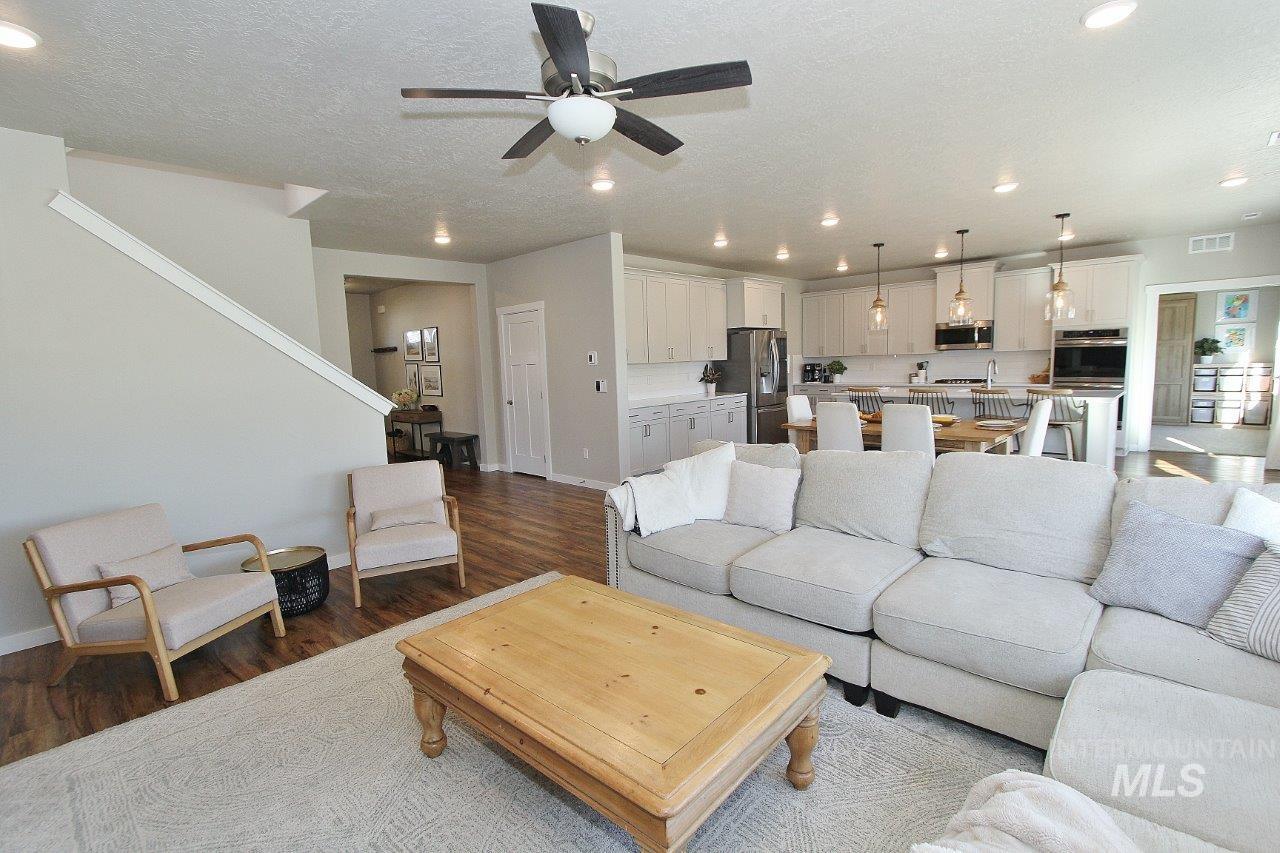 Living area featuring wood finished floors, recessed lighting, a textured ceiling, and ceiling fan