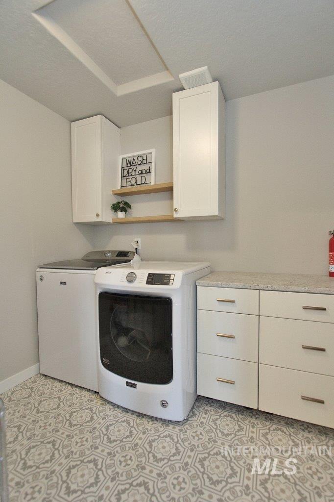 Washroom featuring cabinet space and washing machine and dryer