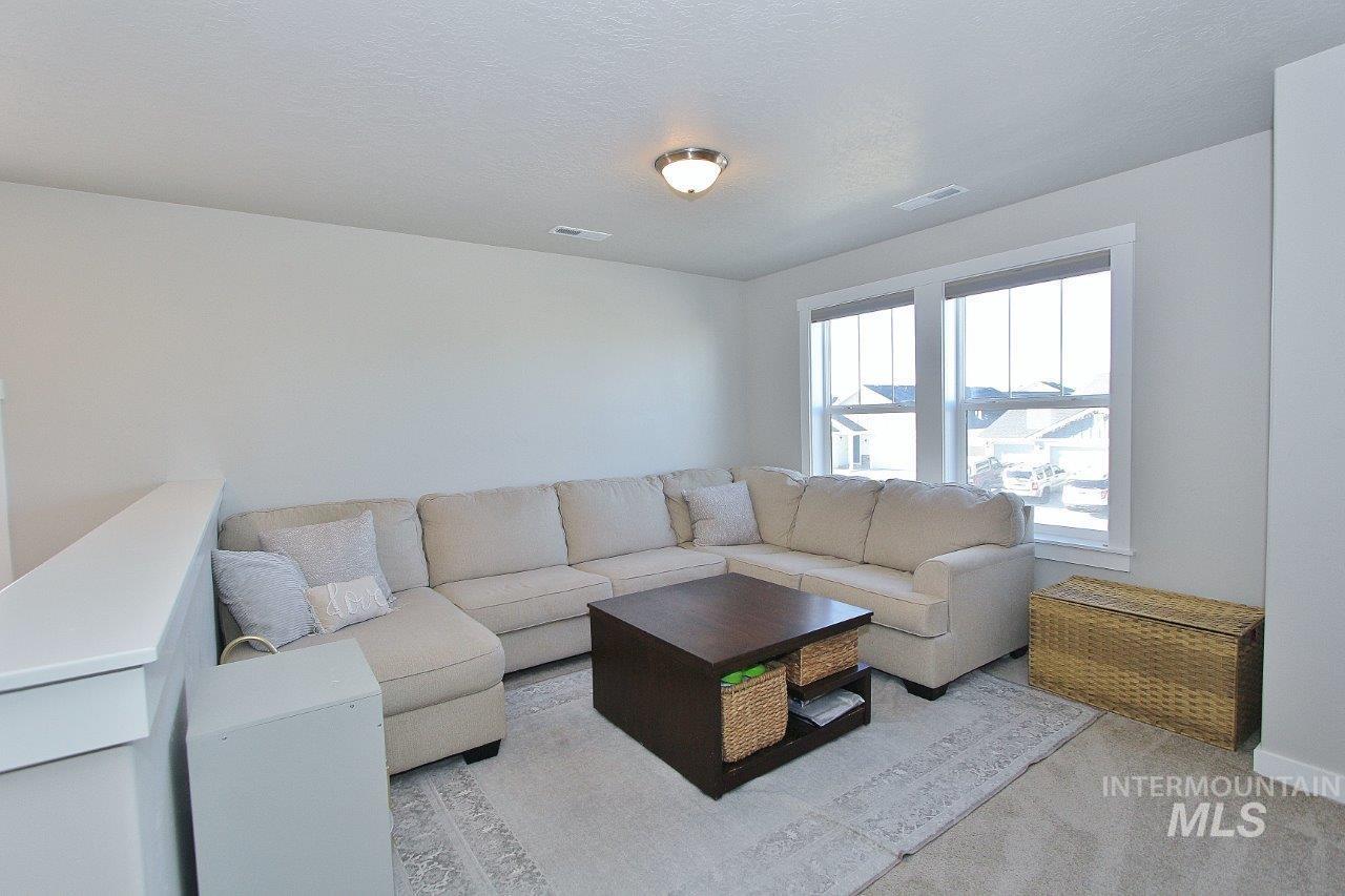 Carpeted living area featuring a textured ceiling