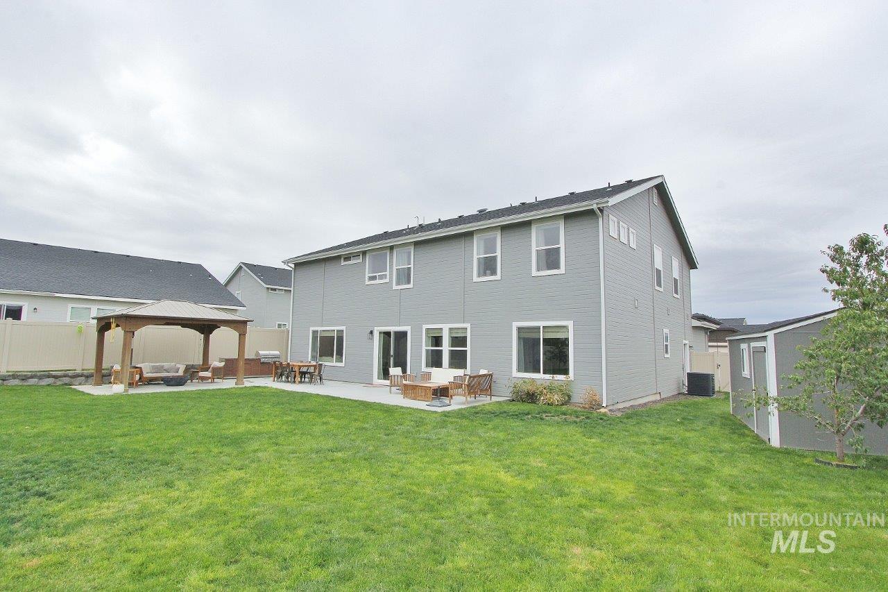 Back of house featuring a gazebo, a patio, an outdoor living space, and a shed