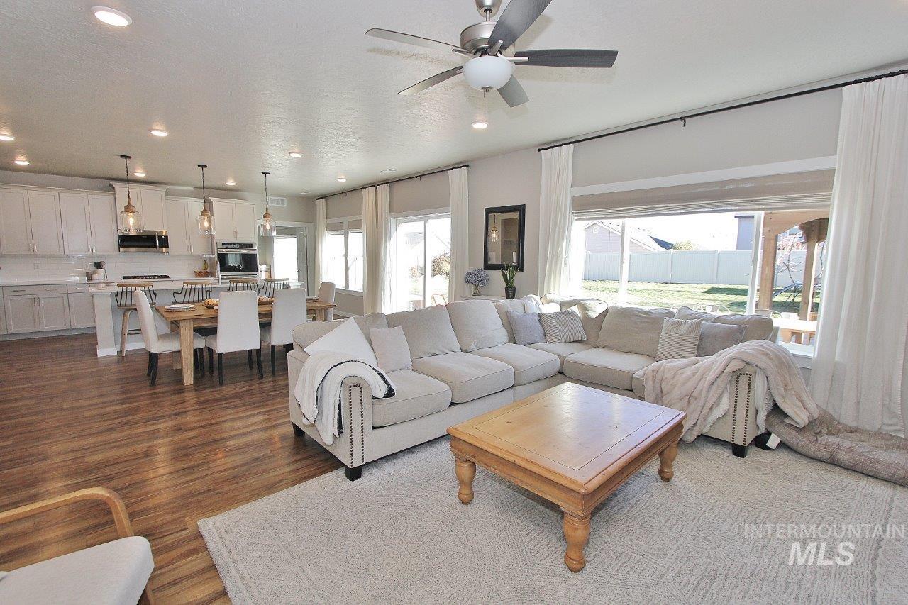 Living room featuring dark wood finished floors, recessed lighting, and a ceiling fan