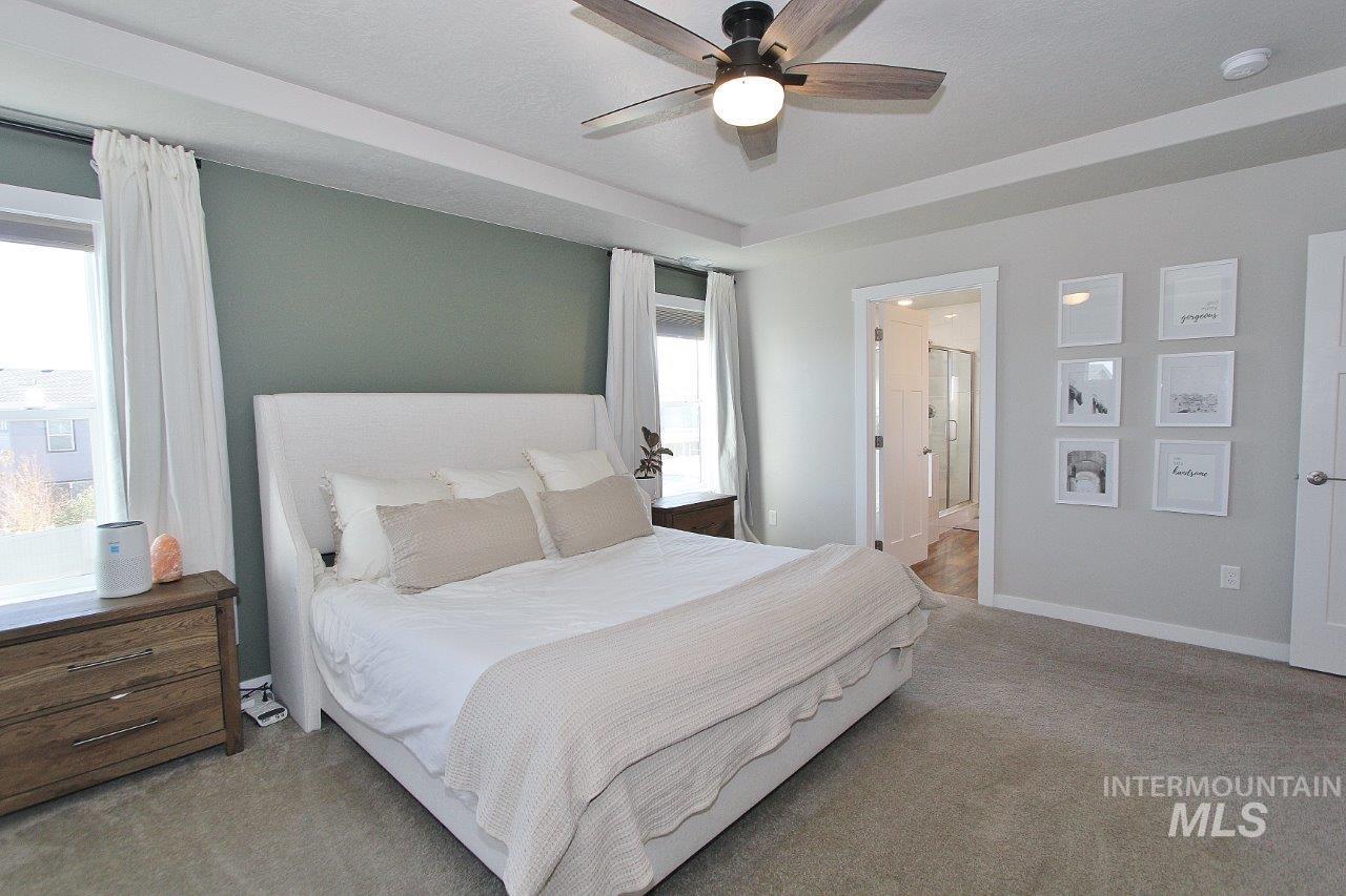 Bedroom featuring carpet floors, a ceiling fan, and ensuite bathroom