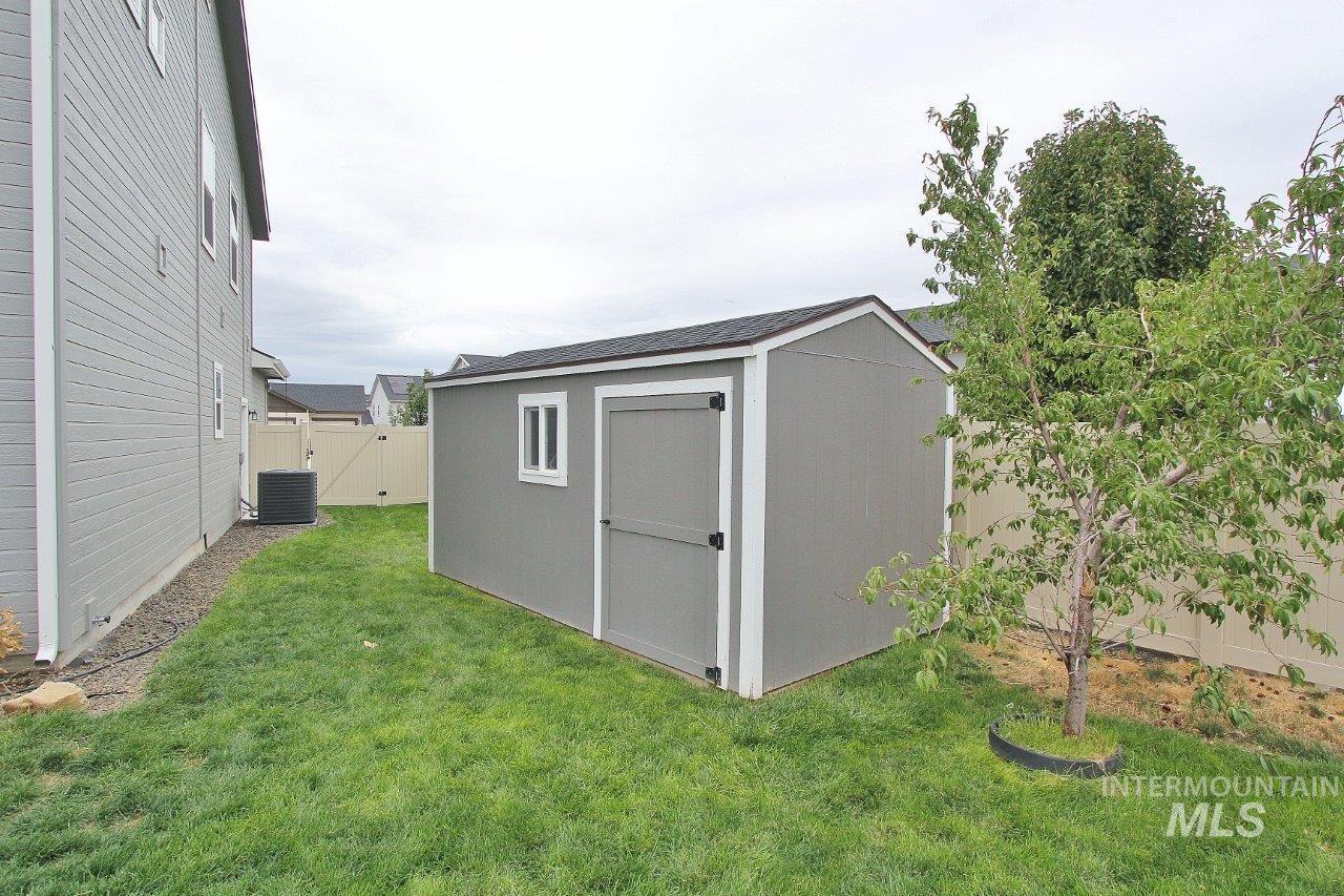 View of shed featuring a fenced backyard and a gate