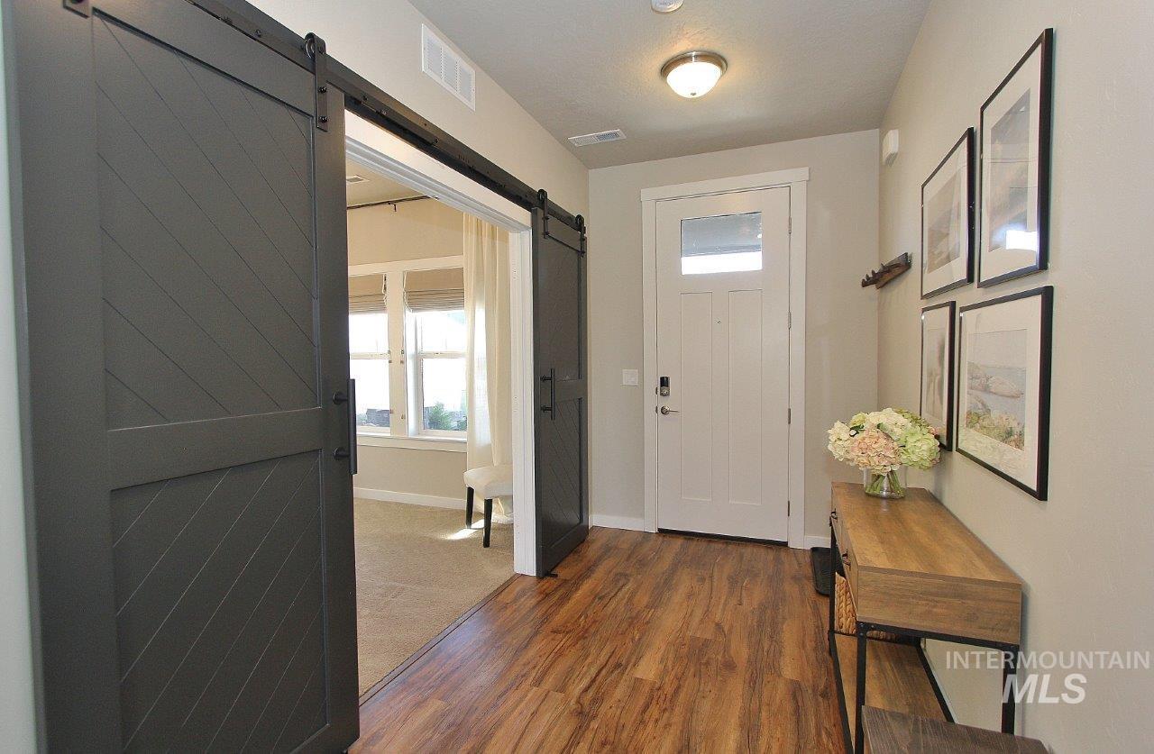 Entrance foyer with a barn door, dark wood-type flooring, and a textured ceiling