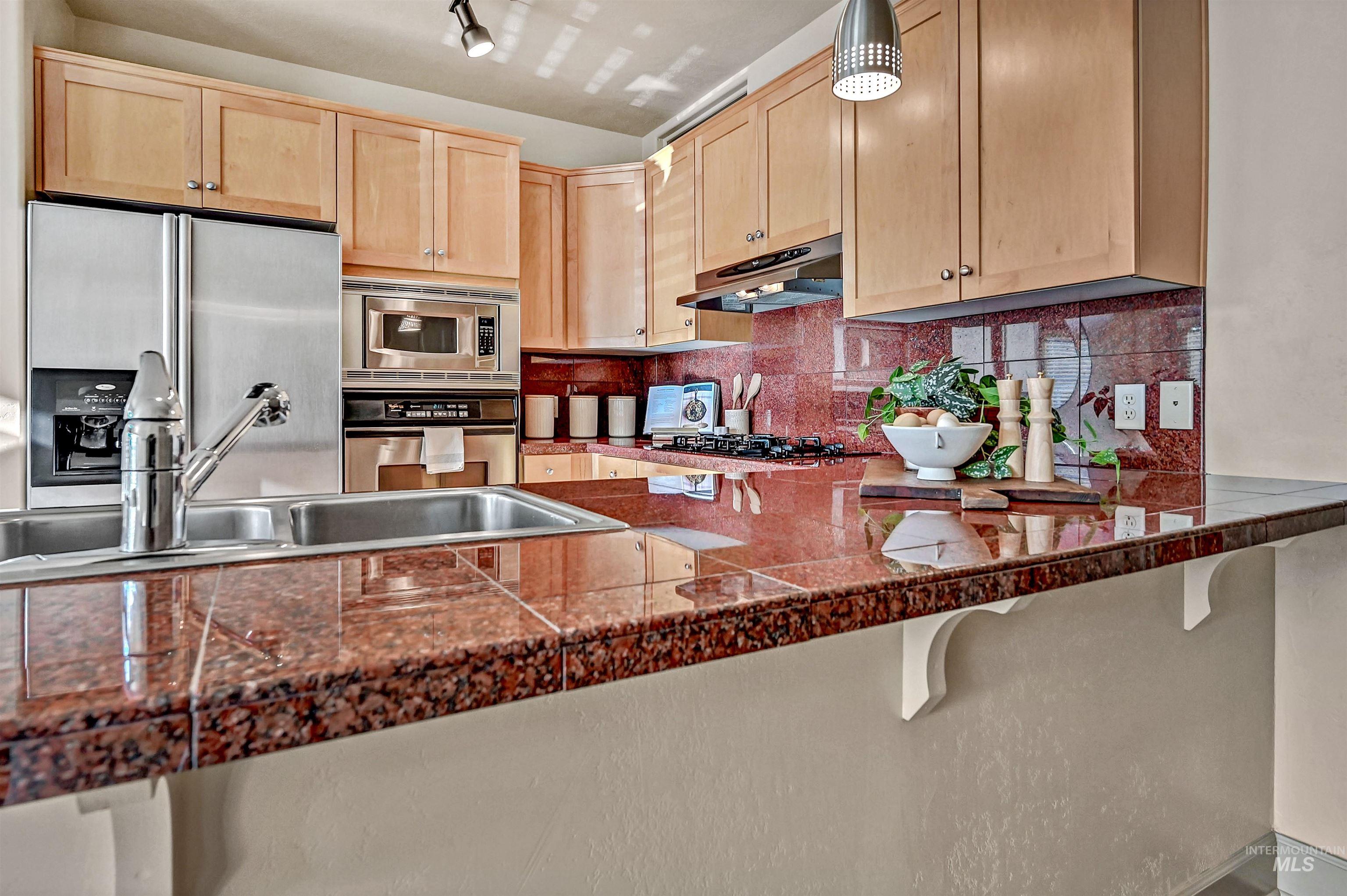 Kitchen features a breakfast bar, granite surfaces, maple cabinetry