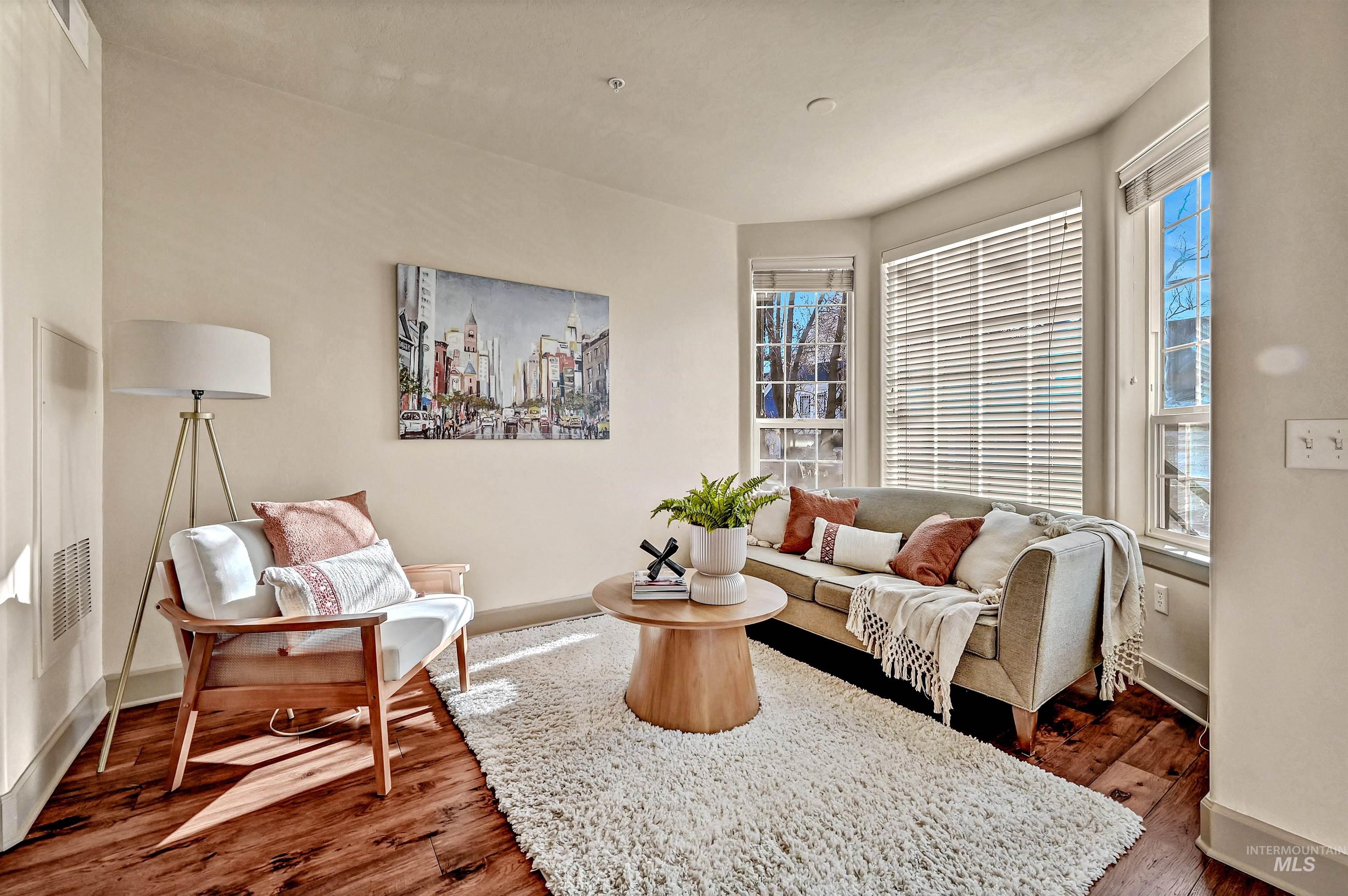 Living area with hardwood floors and  south facing walls of glass for a sunny interior.