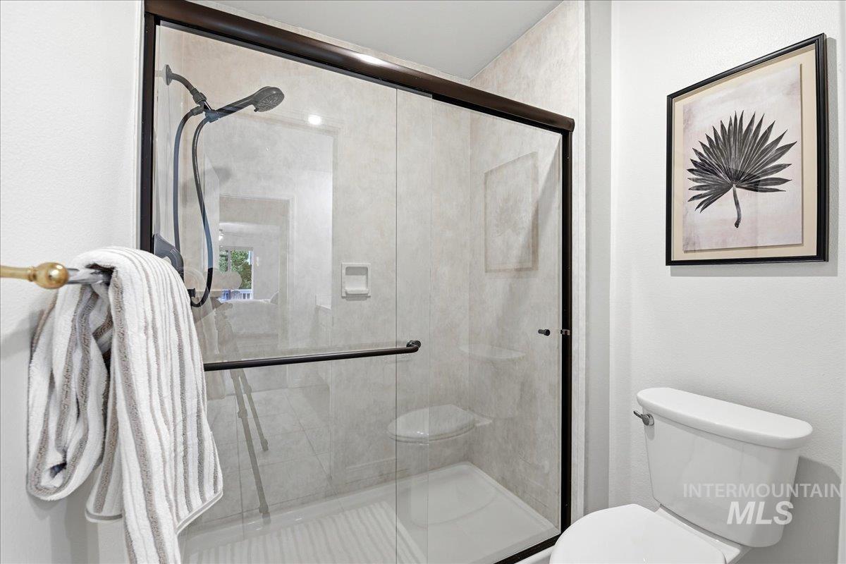 Shower enclosure featuring clear glass panels with dark bronze framing and hardware