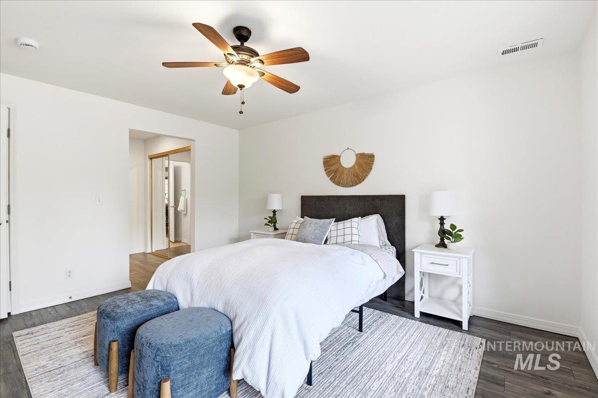 Bedroom featuring wood-finish flooring, a ceiling fan with integrated lighting, and white walls