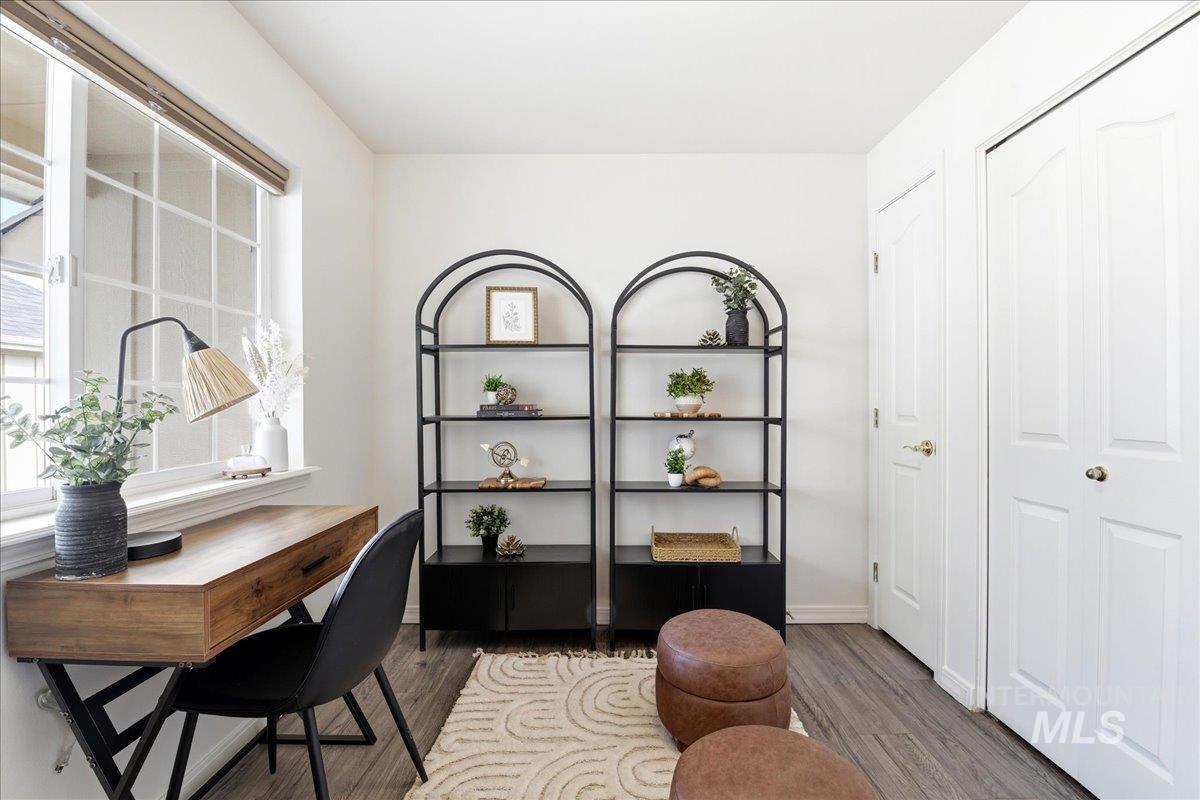 Light-filled room featuring wood-finish flooring and white walls
