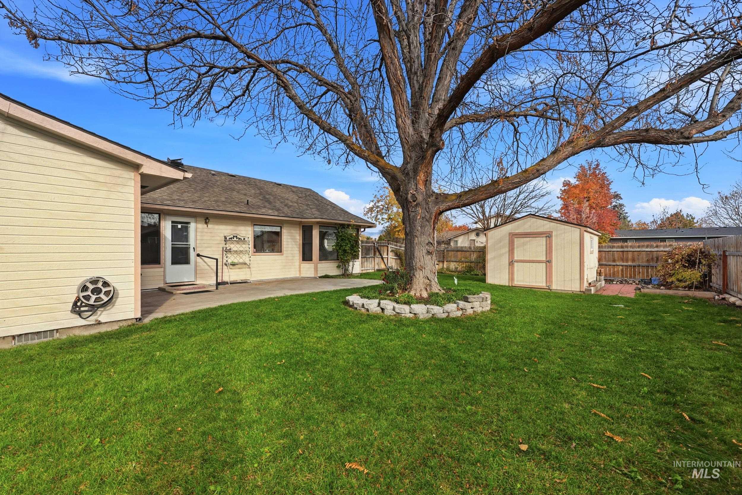 Fenced backyard with a storage shed and a patio