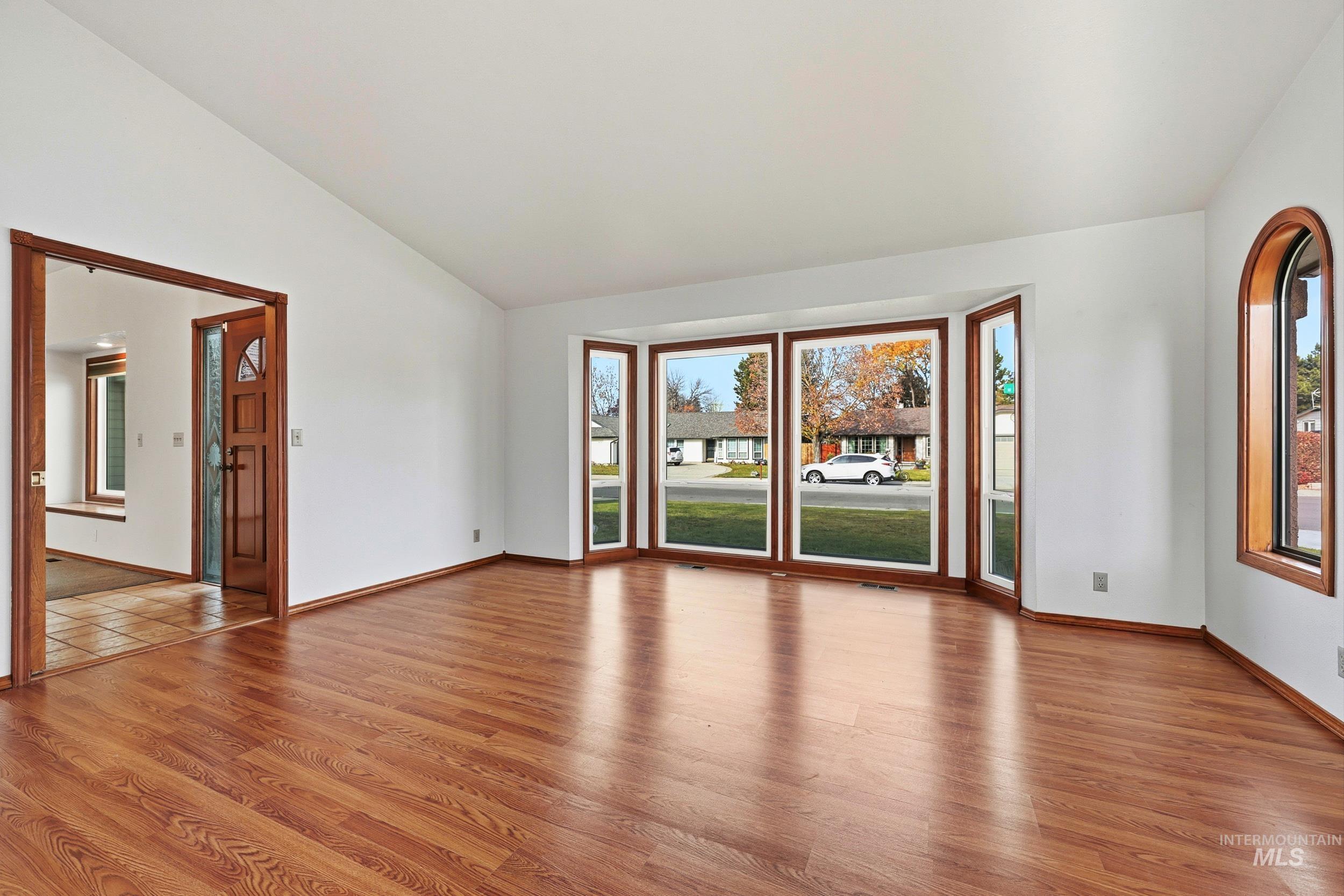 Featuring light wood-style flooring, healthy amount of natural light, and vaulted ceiling