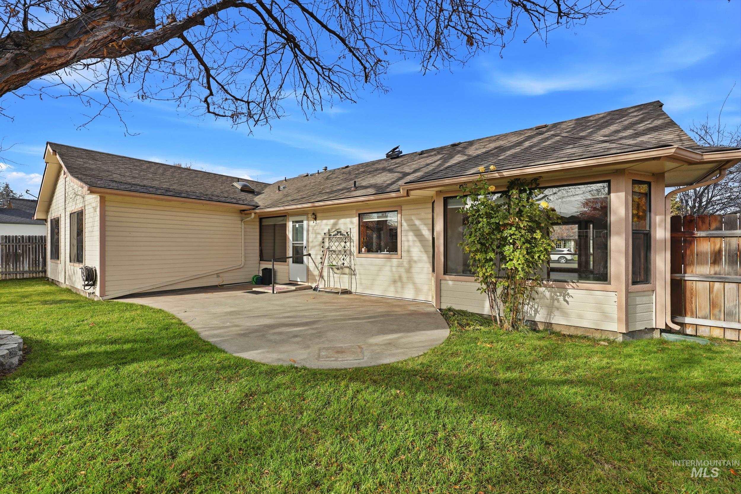 Rear view of property featuring a patio and a shingled roof