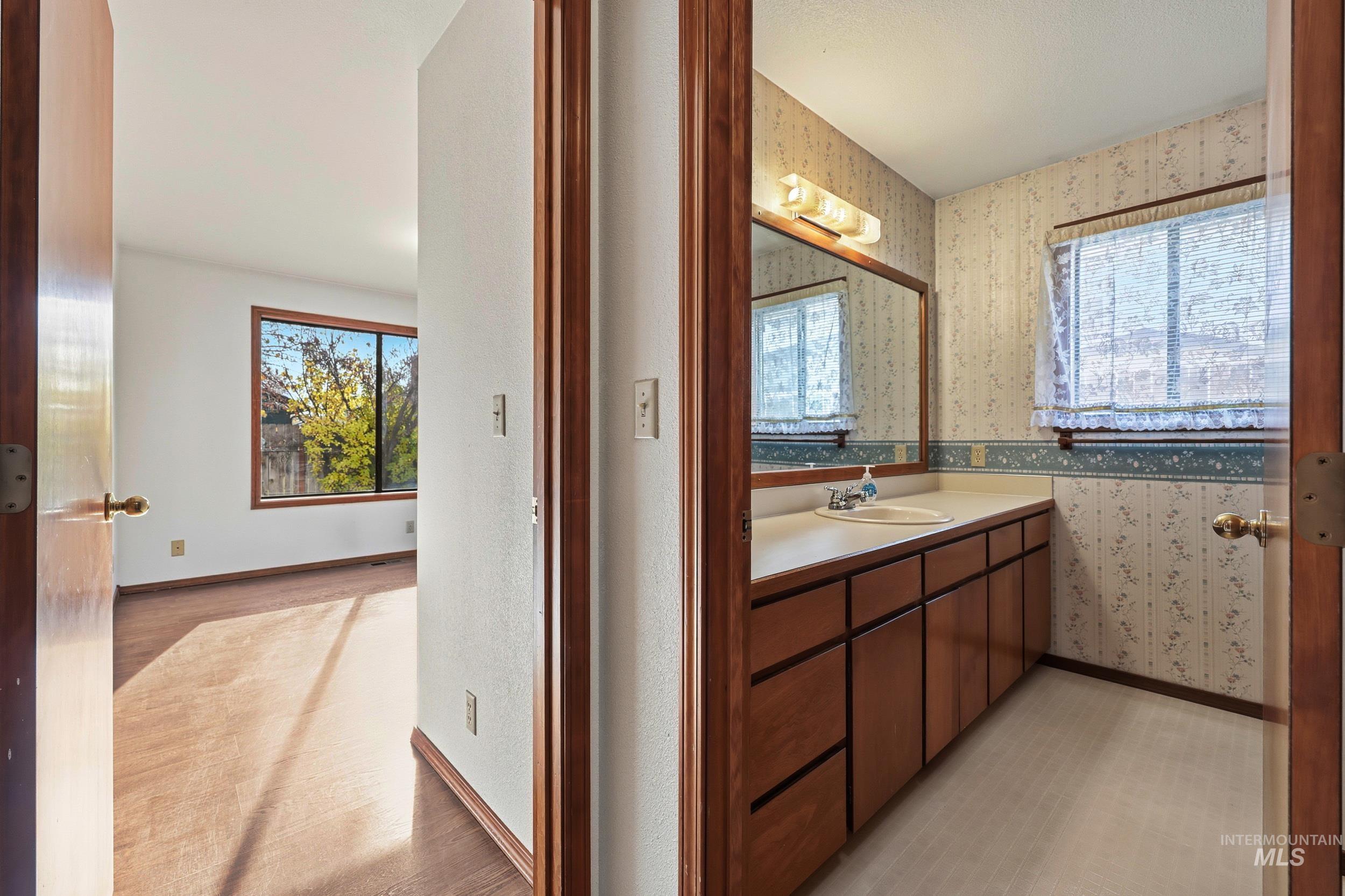Bathroom with vanity and wallpapered walls