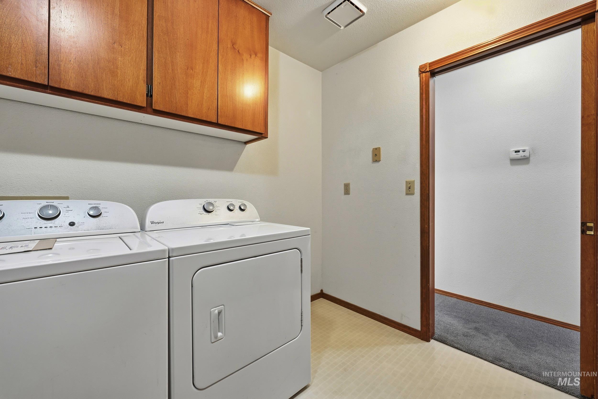 Laundry room featuring separate washer and dryer and cabinet space