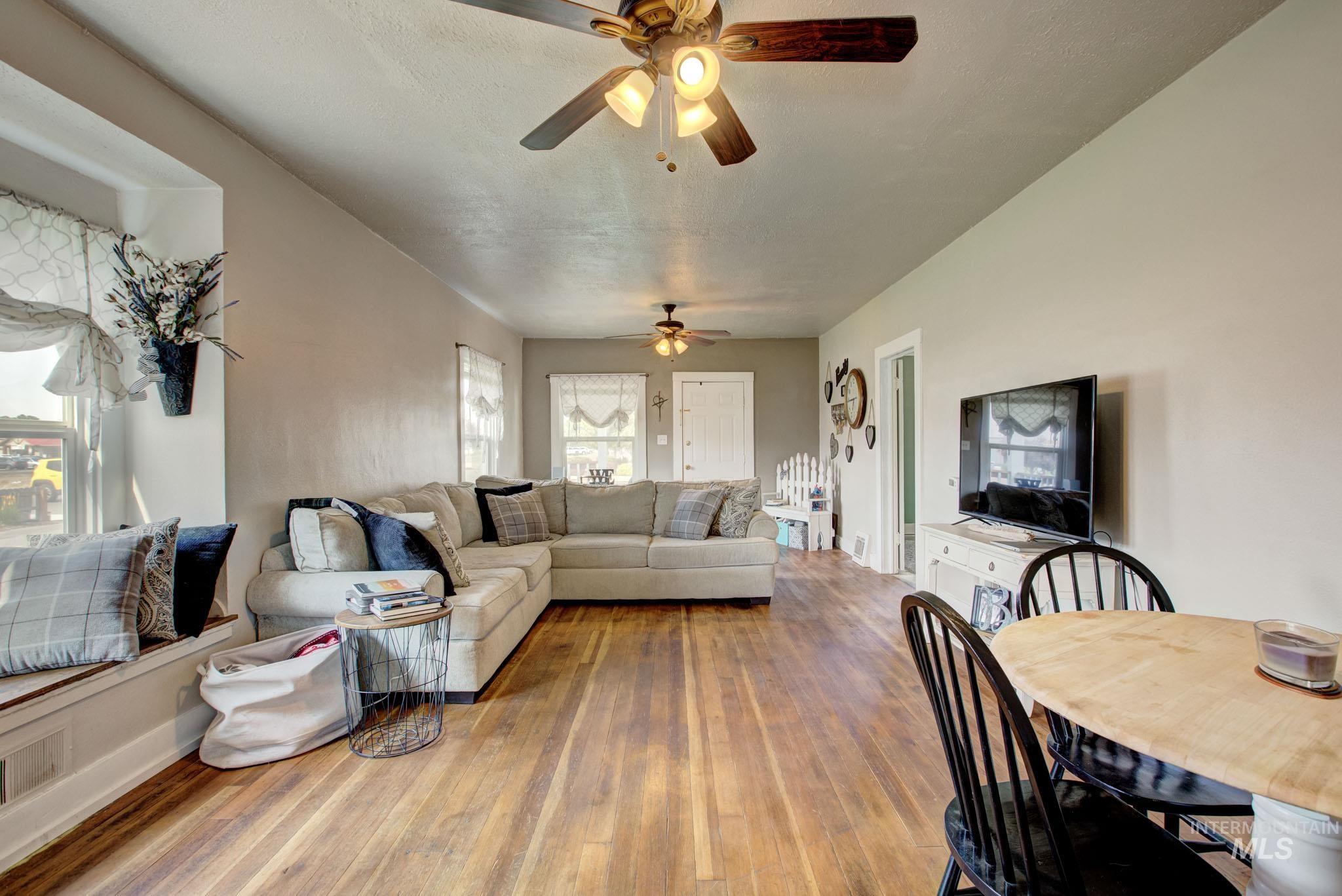 Spacious living area featuring wood-finish flooring and light neutral wall tones