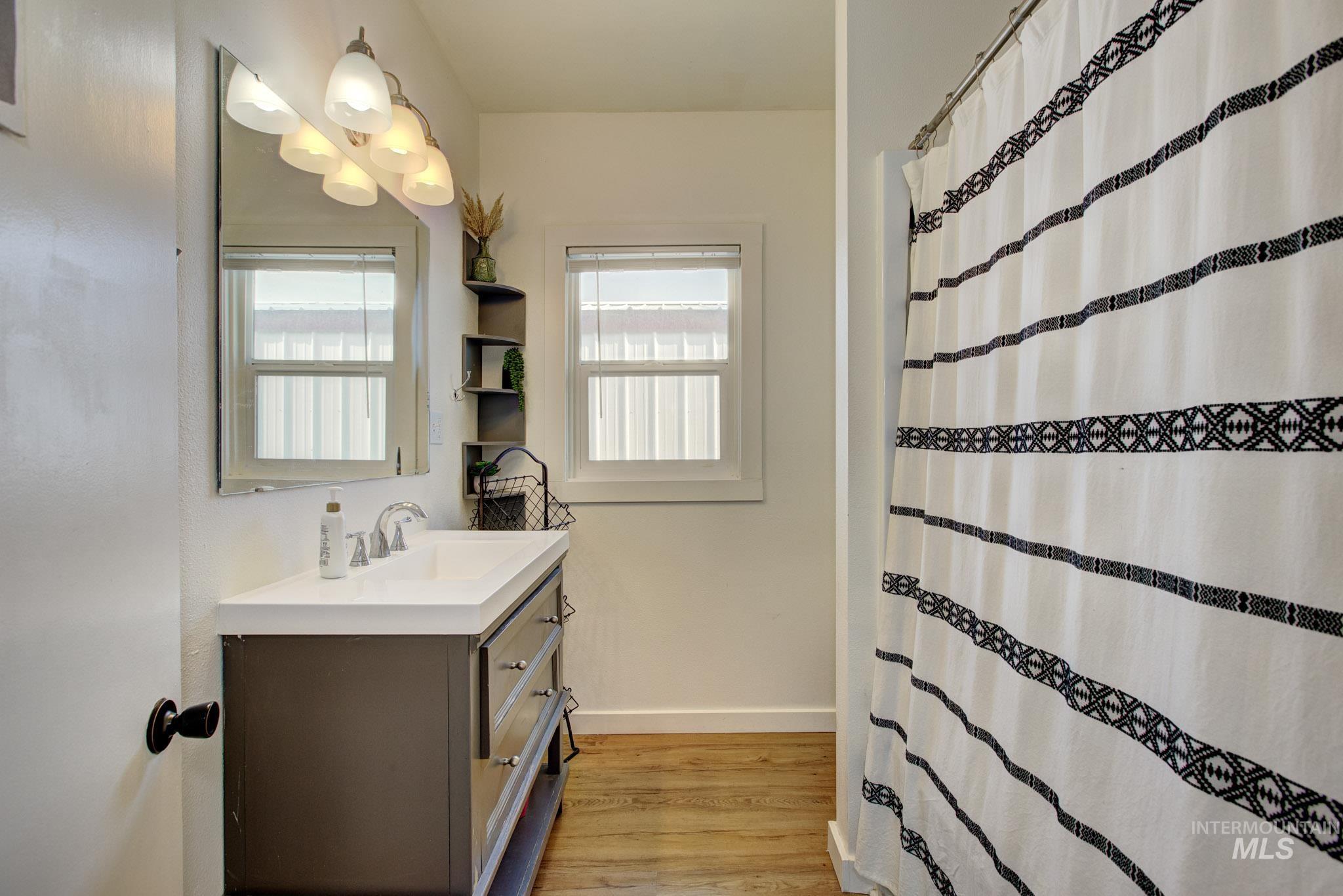 Modern vanity with integrated sink, chrome faucet, and rectangular mirror