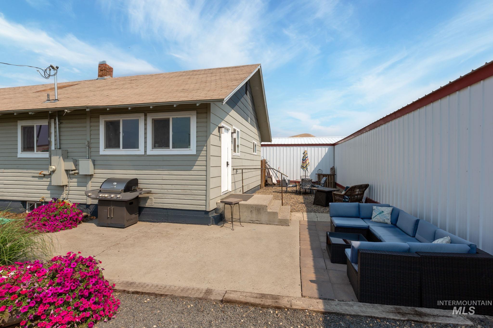 Outdoor patio space featuring a combination of concrete and paver surfaces