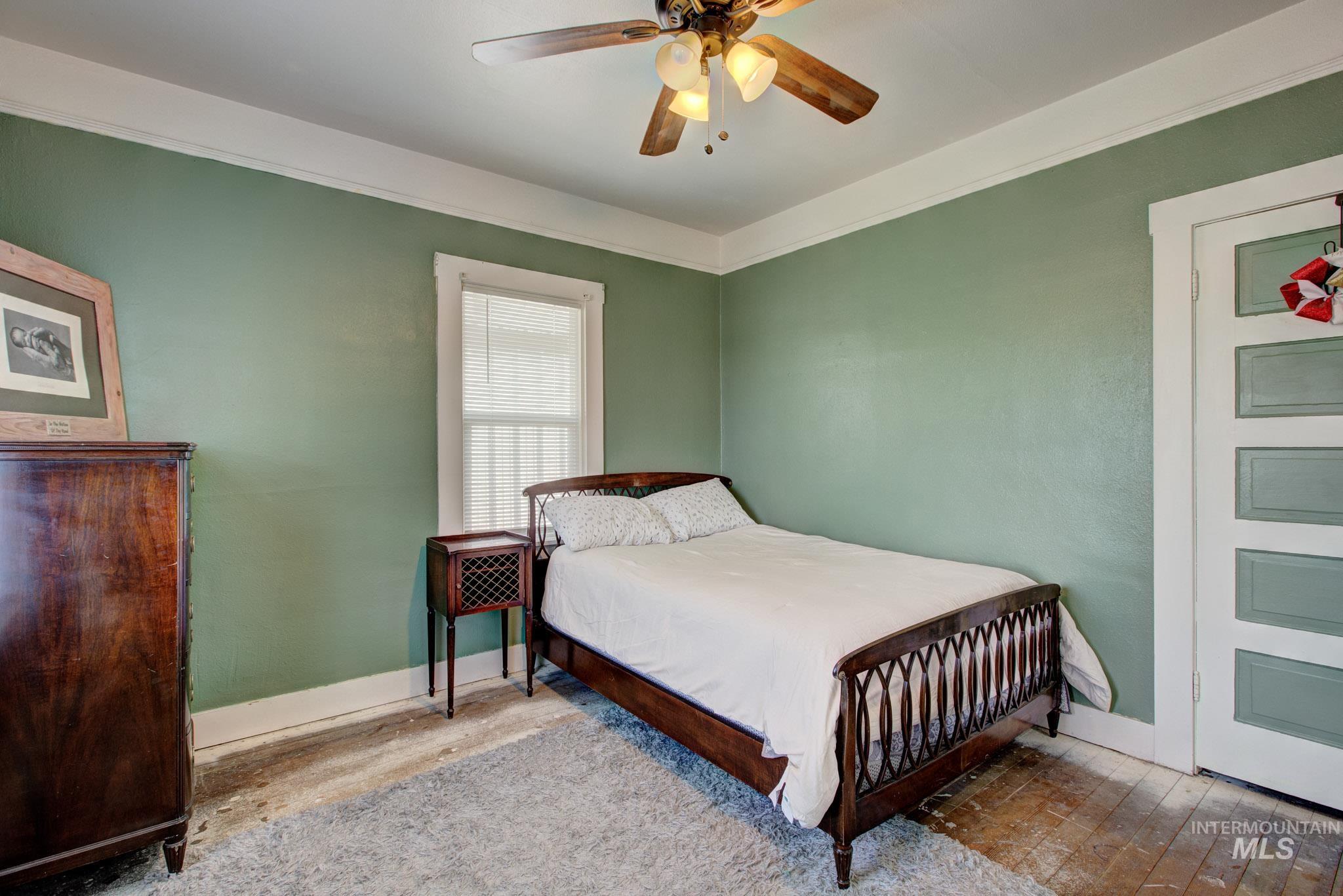 Interior room featuring green walls, white trim, and a window with blinds