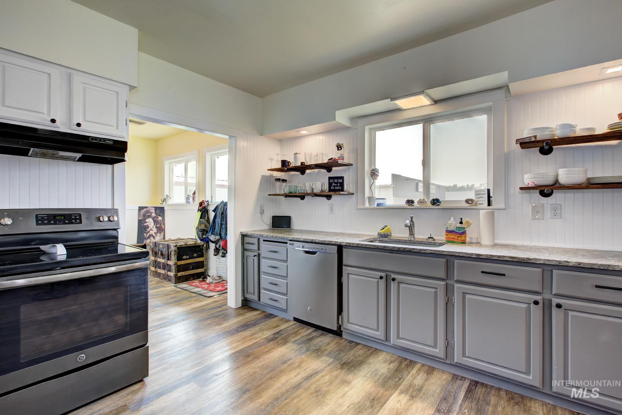 Modern kitchen featuring wood-finish flooring and two-tone cabinetry