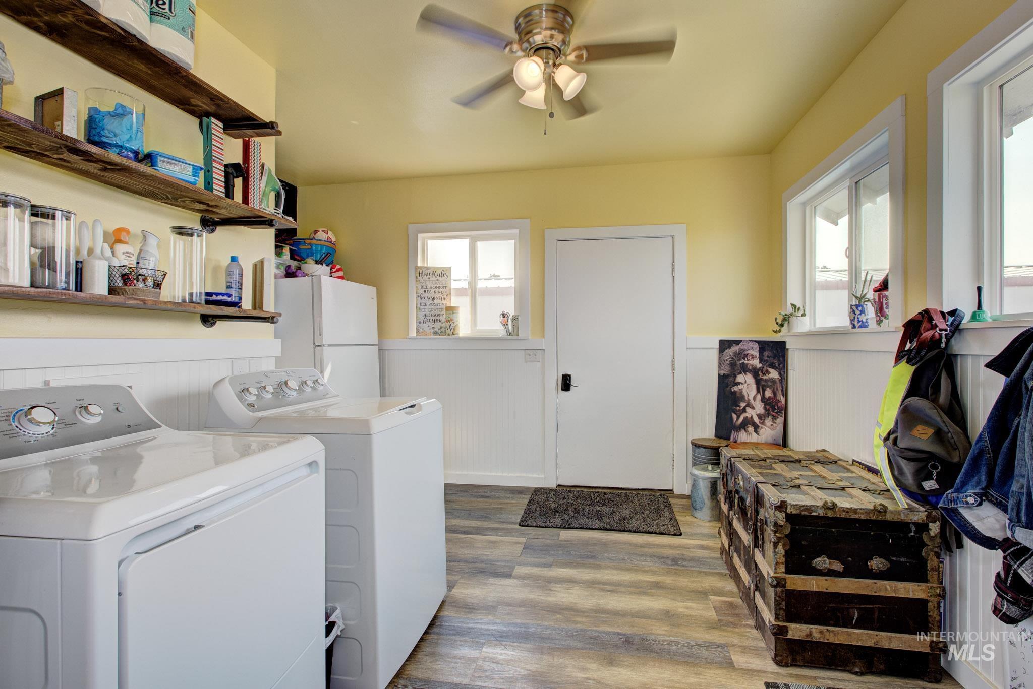 Utility room featuring wood-finish flooring, white beadboard wainscoting, and a ceiling fan