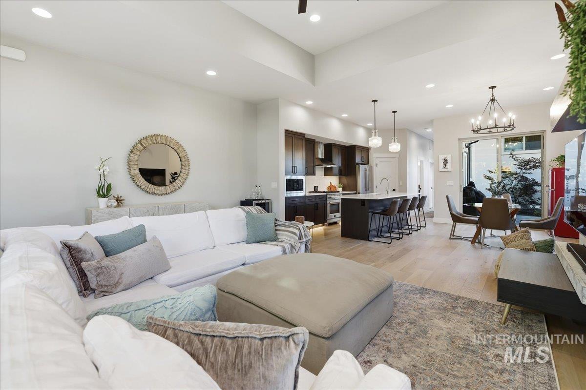 Living room with light wood finished floors, recessed lighting, and a chandelier