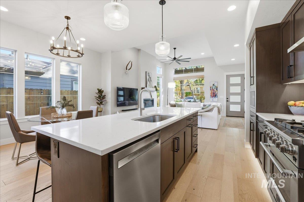 Kitchen featuring dark brown cabinets, stainless steel appliances, recessed lighting, light wood-style floors, and a ceiling fan