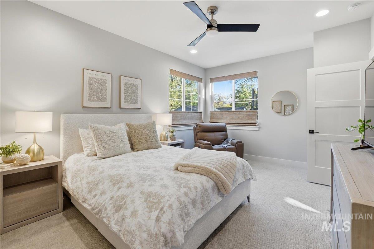 Bedroom with light carpet, a ceiling fan, and recessed lighting