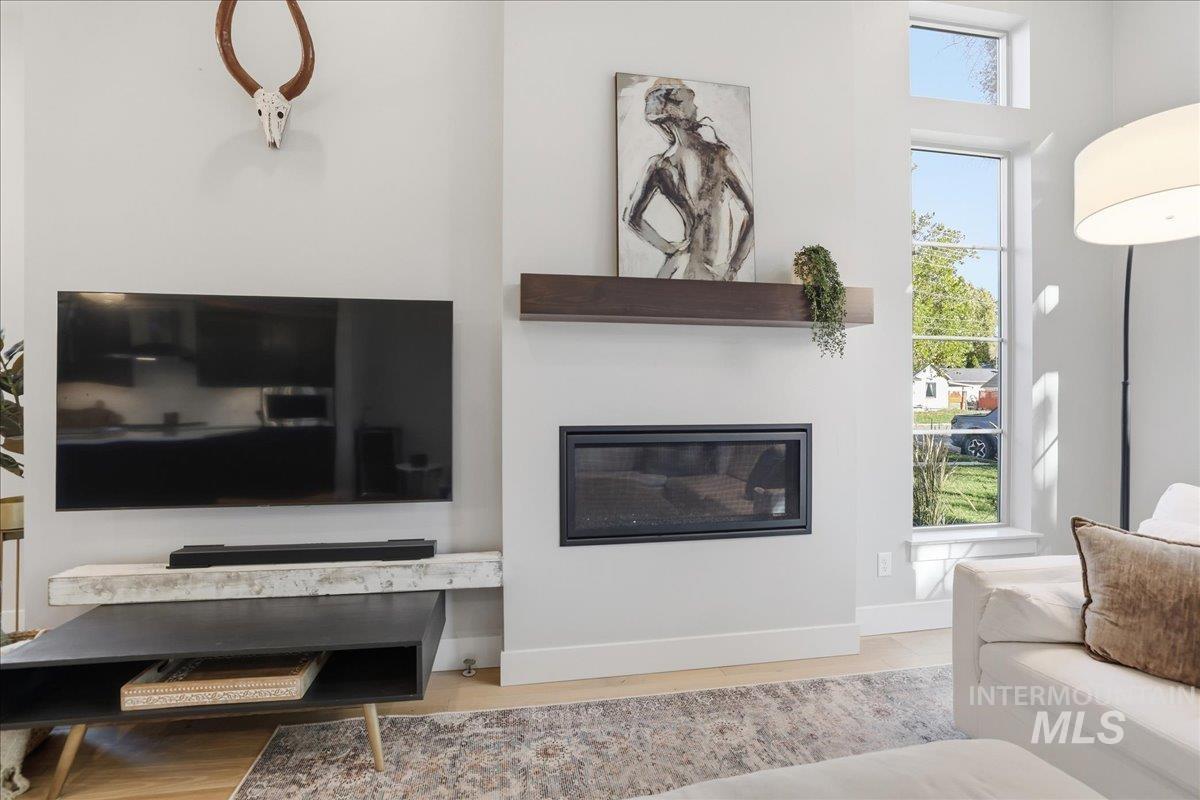 Living area featuring a glass covered fireplace and light wood-style flooring