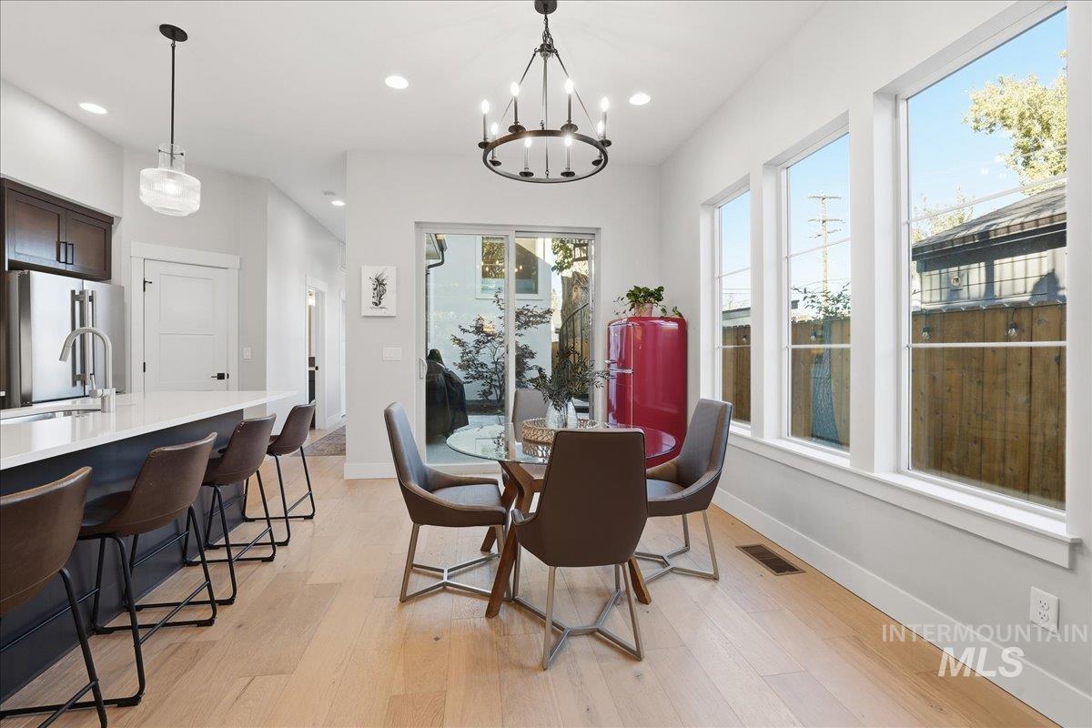Dining area featuring light wood-style floors, recessed lighting, and a chandelier