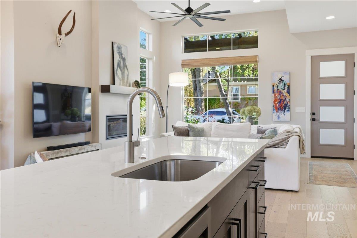 Kitchen with open floor plan, light stone countertops, light wood finished floors, healthy amount of natural light, and recessed lighting