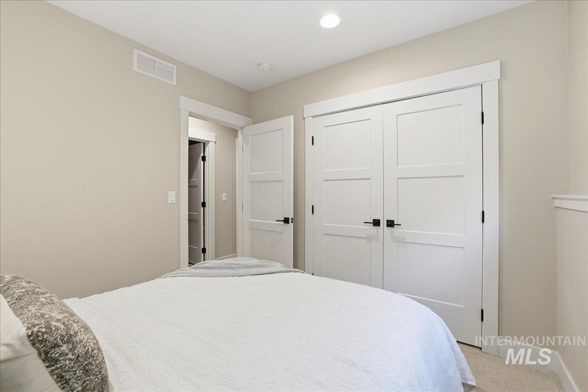 Carpeted bedroom with a closet and recessed lighting