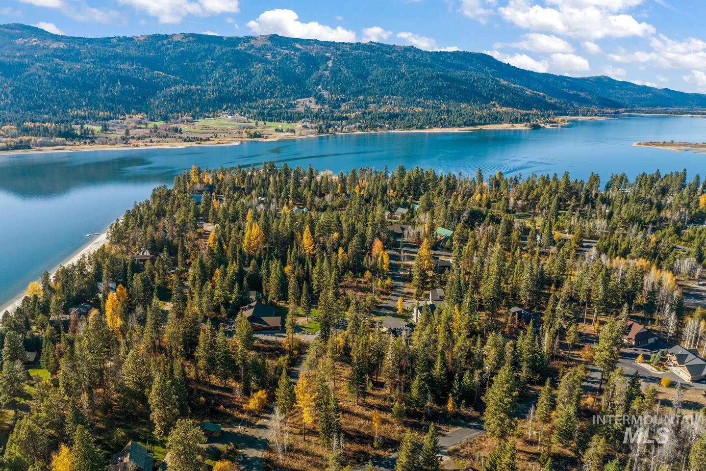 Aerial view of property and surrounding area featuring a water and mountain view