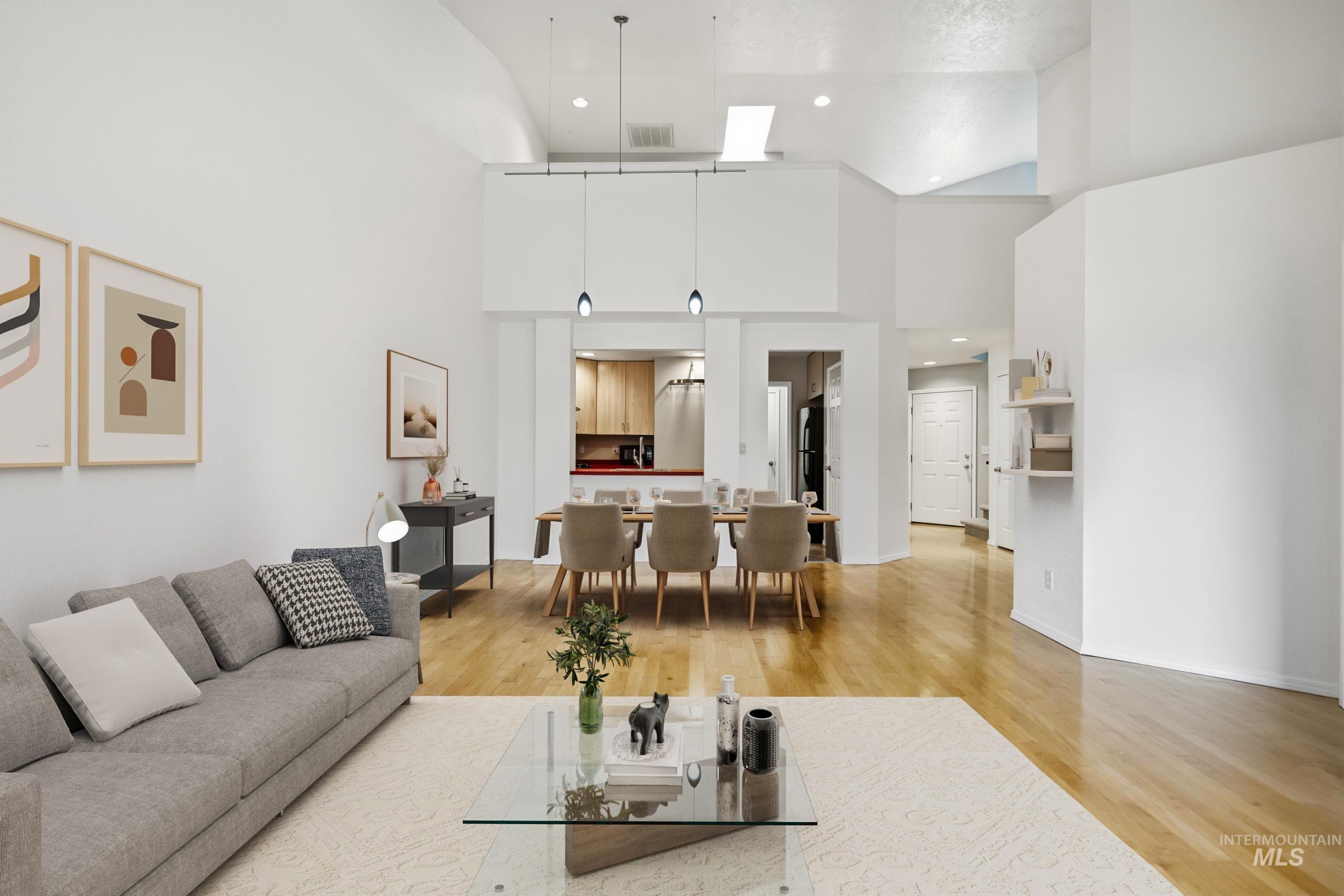 Living room with light wood-style flooring, recessed lighting, and a high ceiling