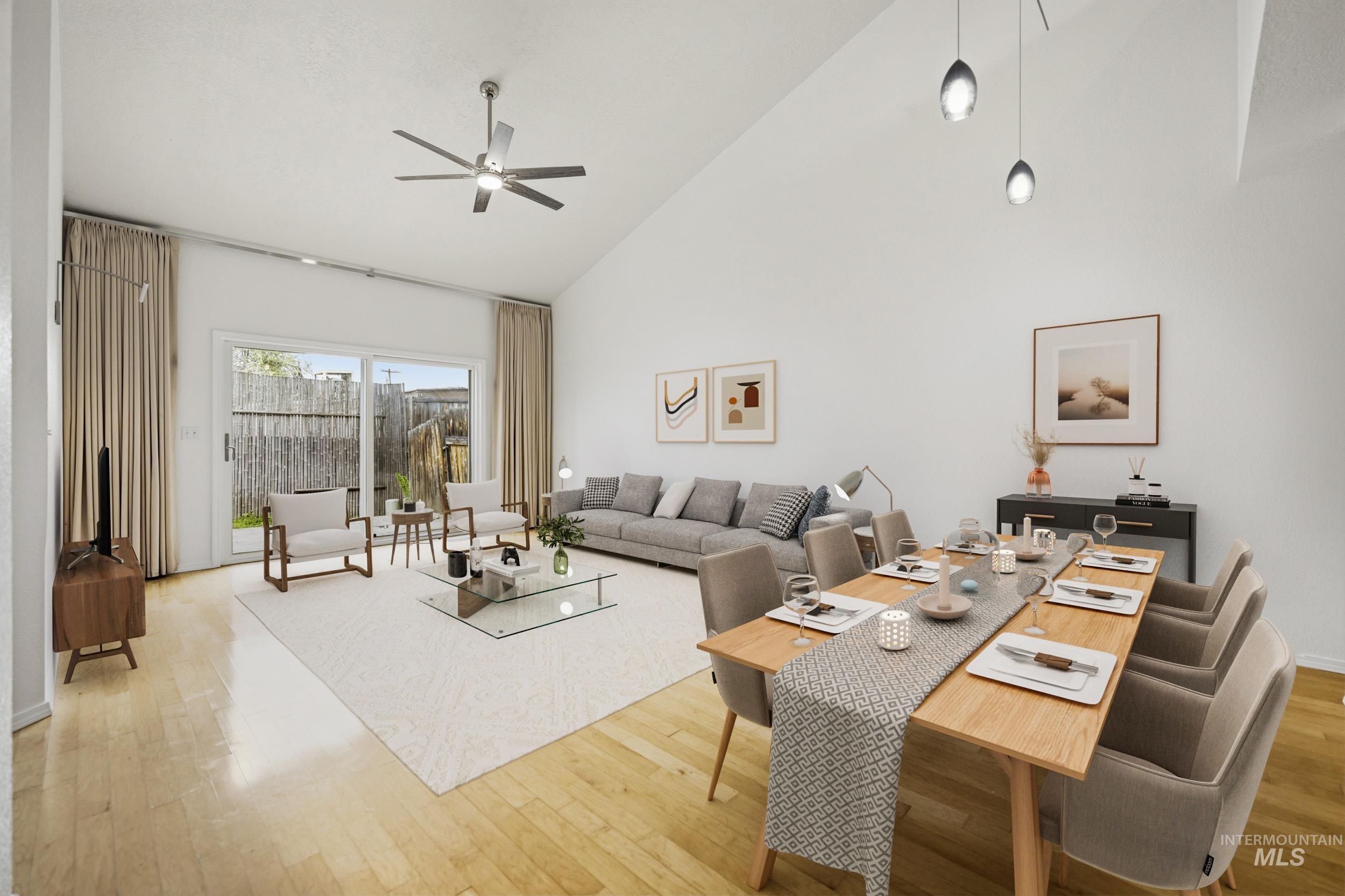 Living room featuring light wood-style floors, vaulted ceiling, and a ceiling fan