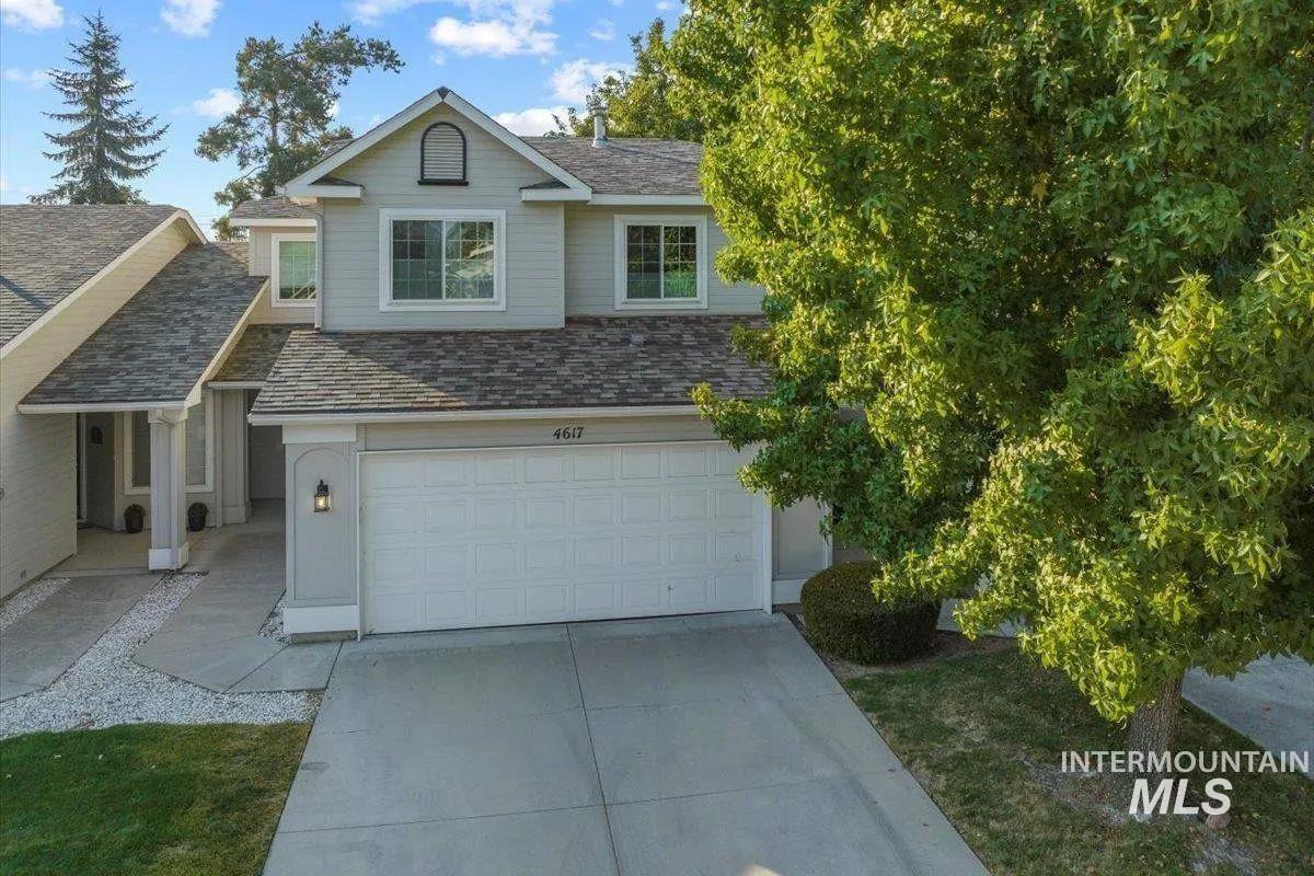 Traditional home with a shingled roof, concrete driveway, and an attached garage