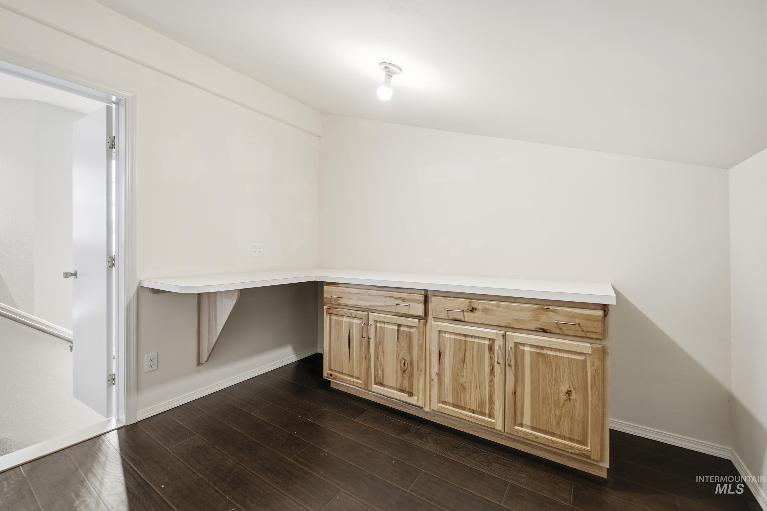 Unfurnished office with dark wood finished floors and baseboards