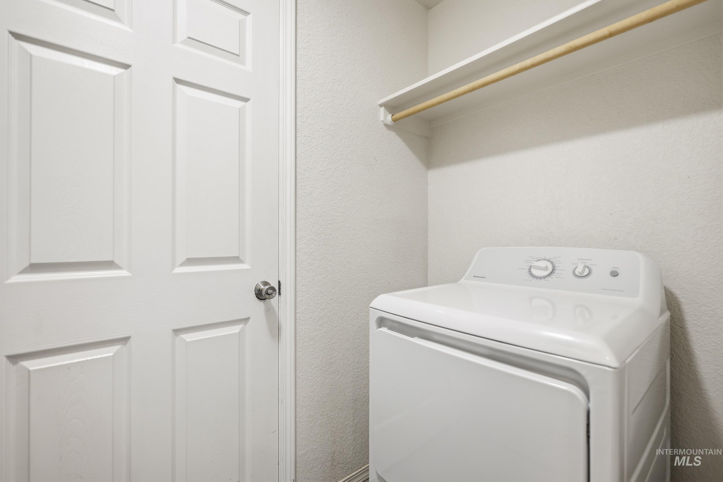 Laundry area with washer / dryer and a textured wall