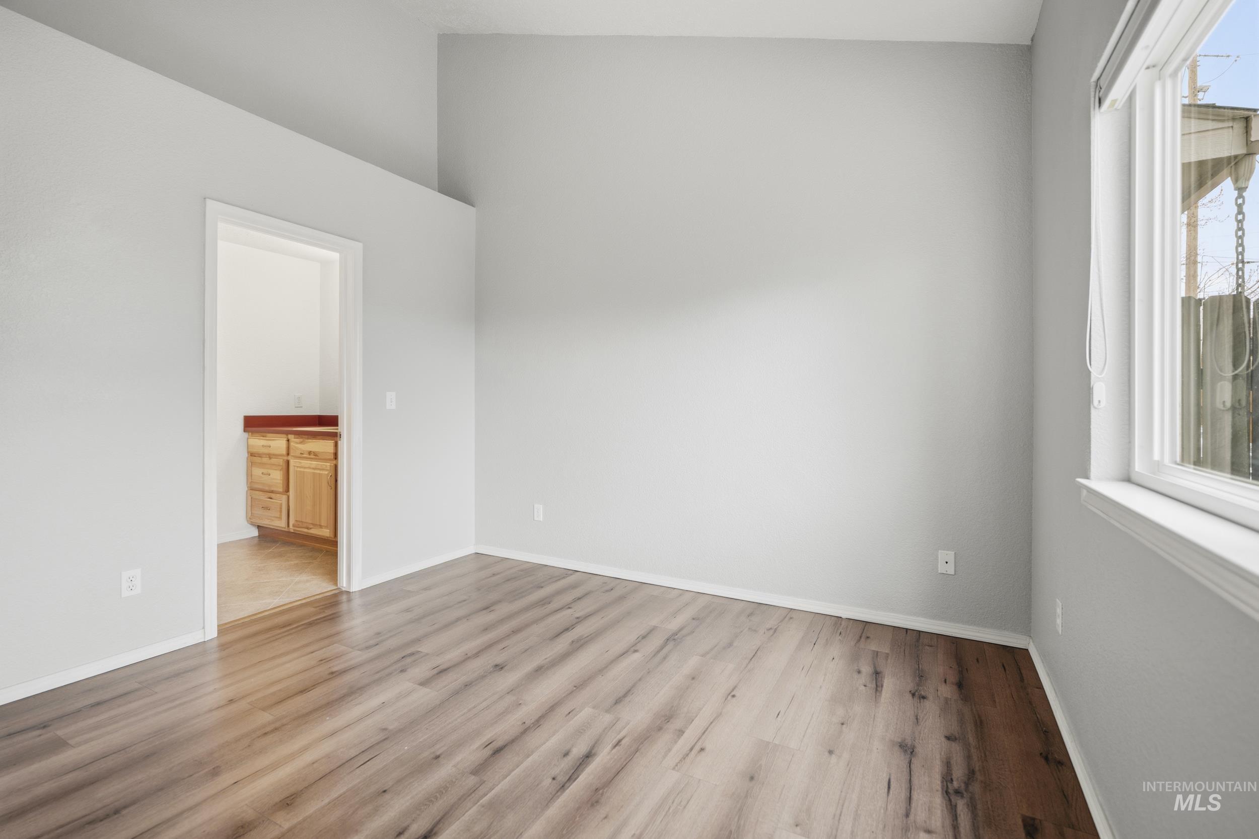 Empty room with light wood-type flooring and baseboards