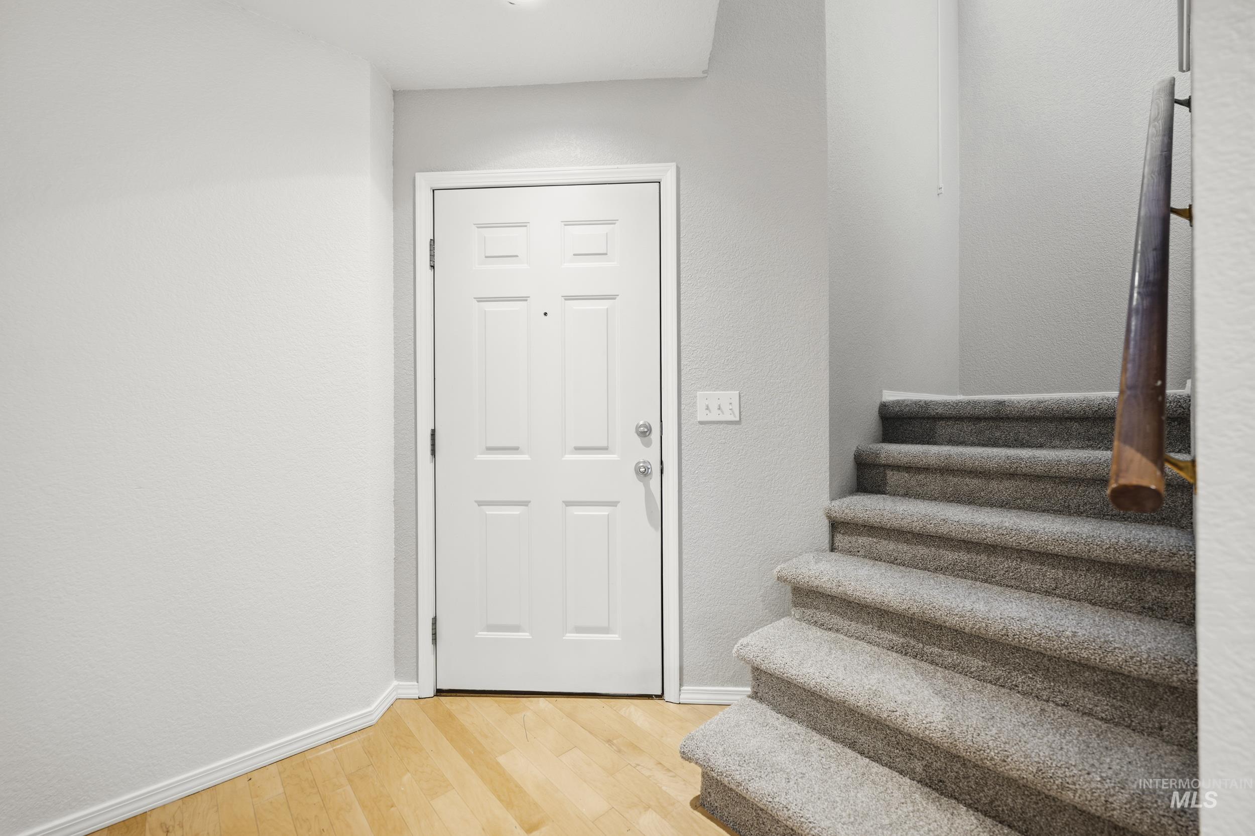 Foyer with light wood-style flooring and stairway