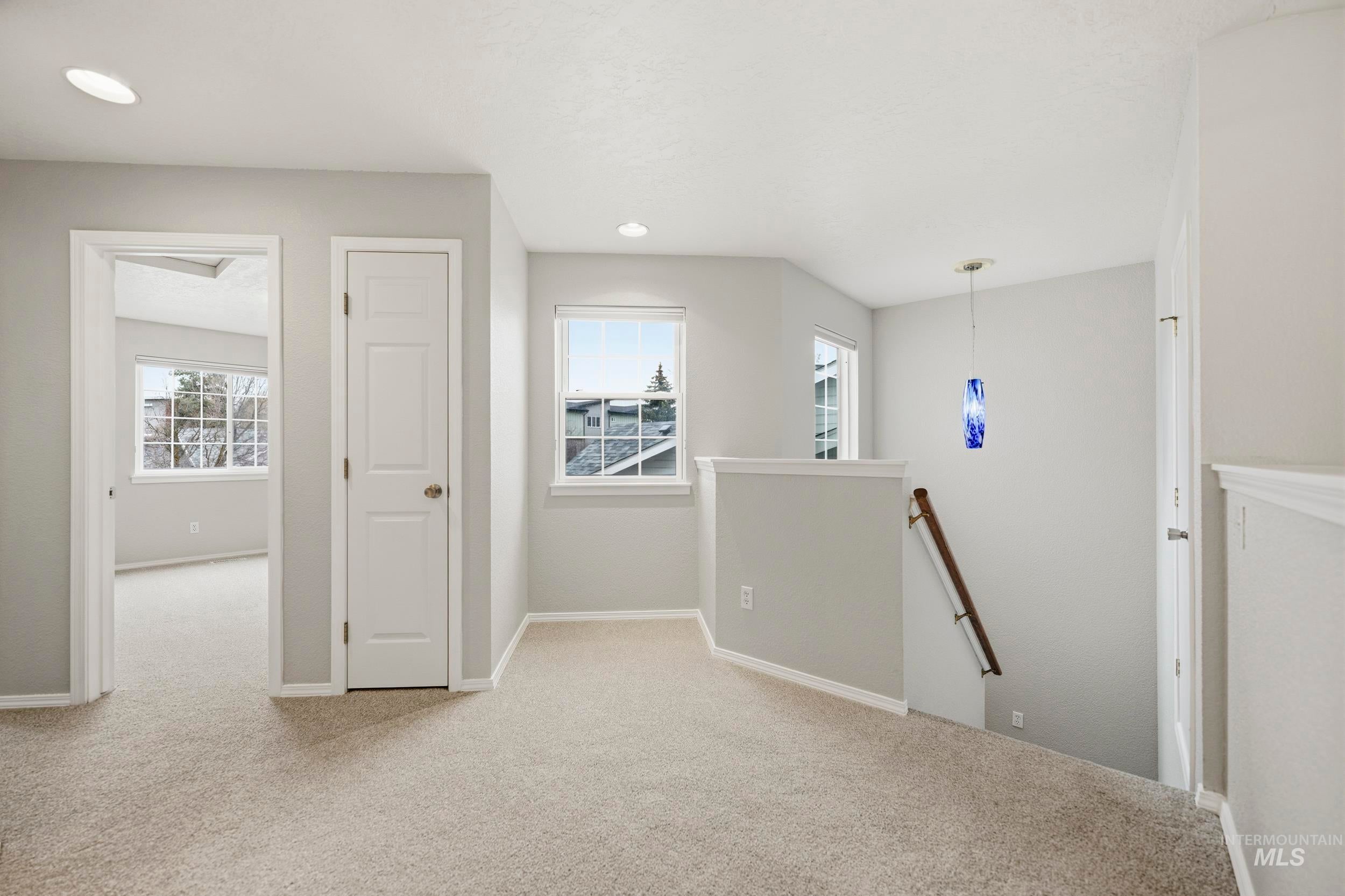 Hall featuring an upstairs landing, light carpet, and recessed lighting