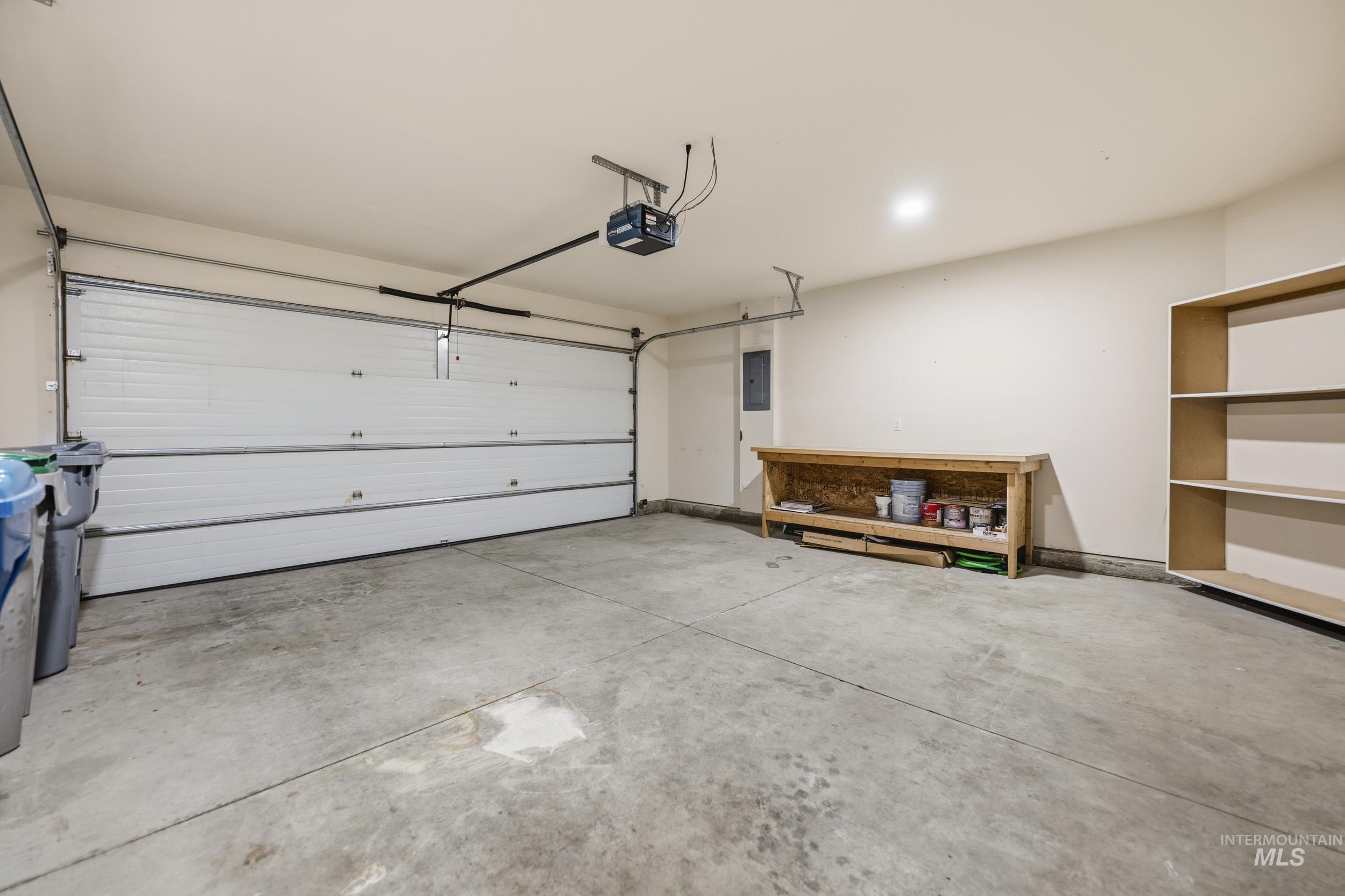 Garage featuring electric panel and a garage door opener