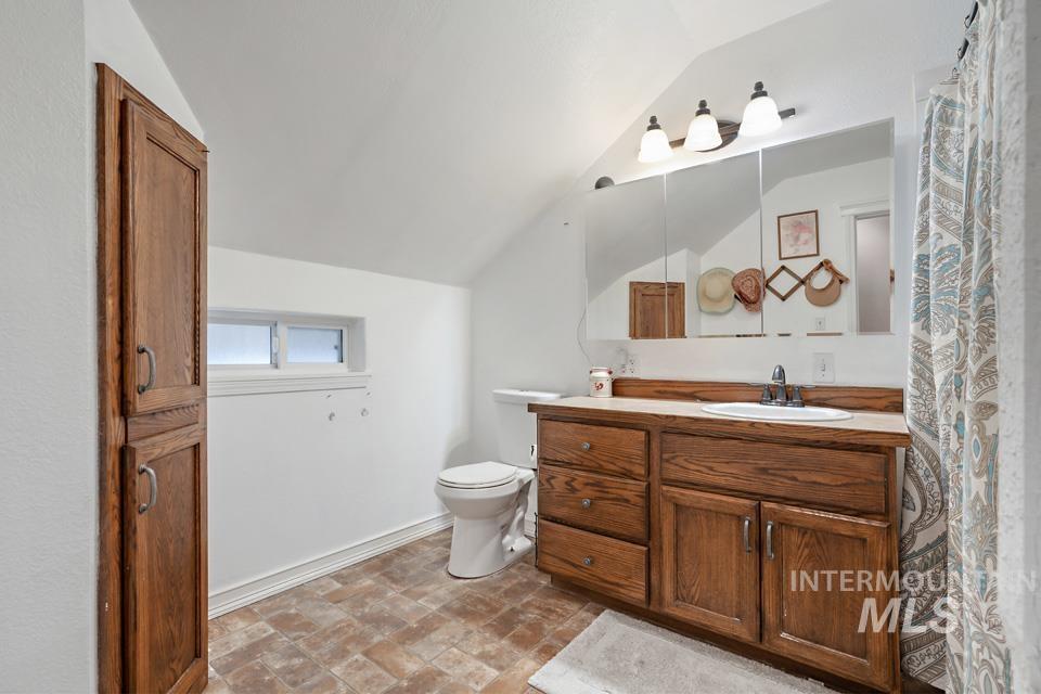 Bathroom featuring vanity and lofted ceiling