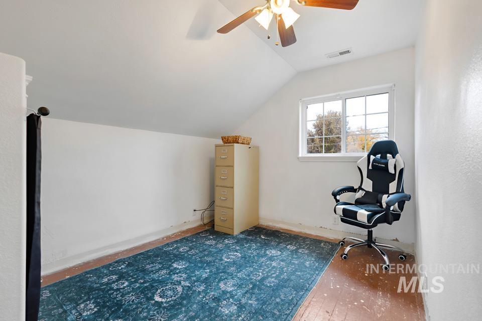 Unfurnished room with lofted ceiling, ceiling fan, and wood-type flooring