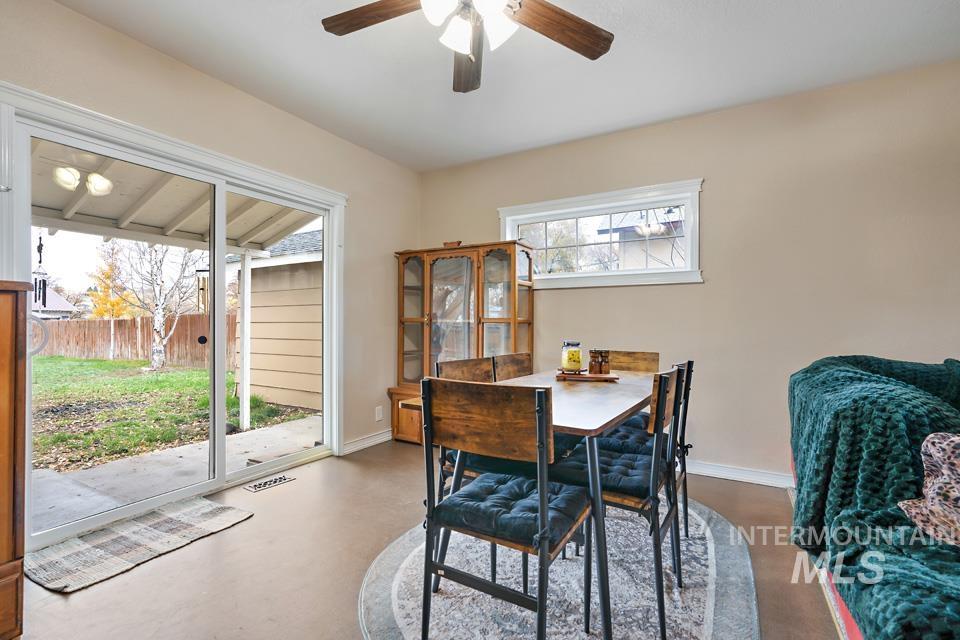 Dining room with concrete flooring and a ceiling fan