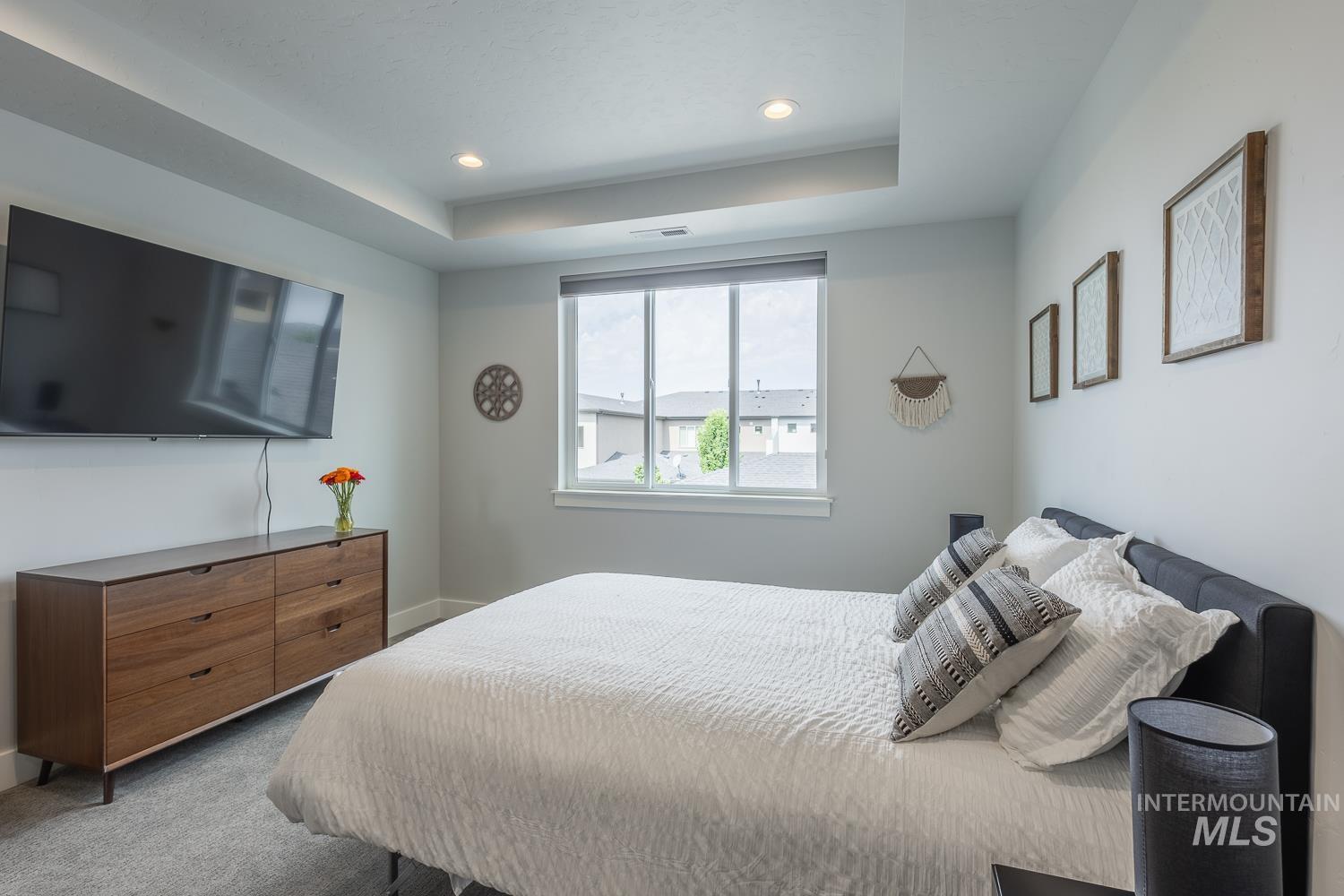 Bedroom featuring carpet, a tray ceiling, and recessed lighting