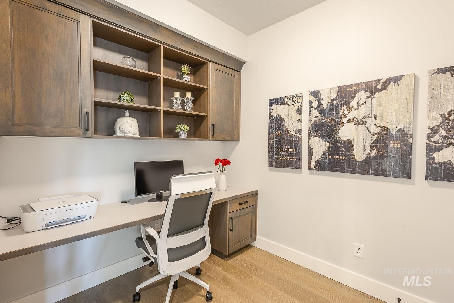 Office featuring light wood-style floors and built in desk