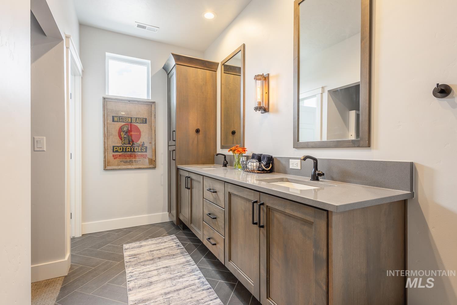 Full bathroom featuring double vanity, dark tile patterned flooring, and recessed lighting