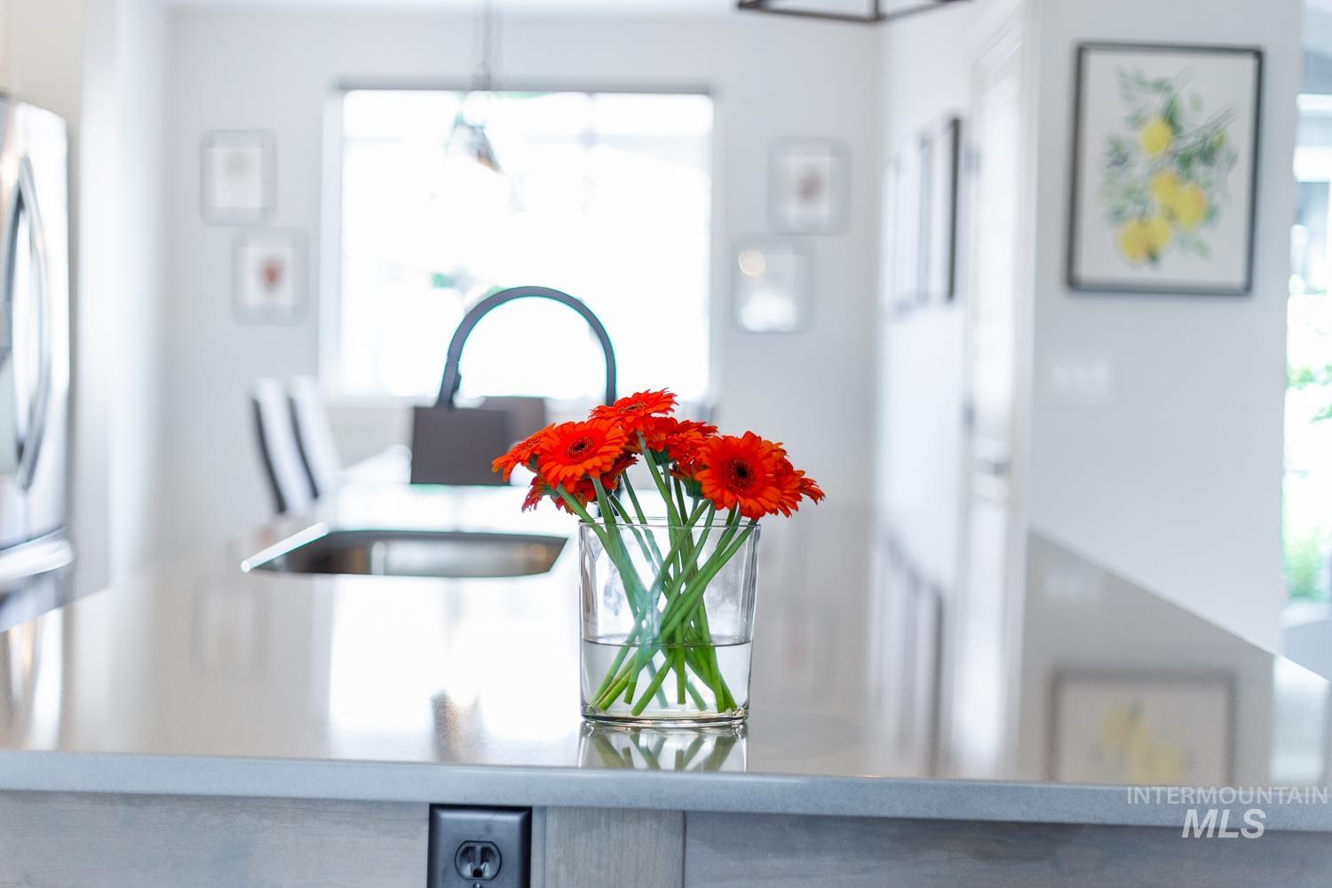 Kitchen view of freestanding refrigerator and light stone countertops